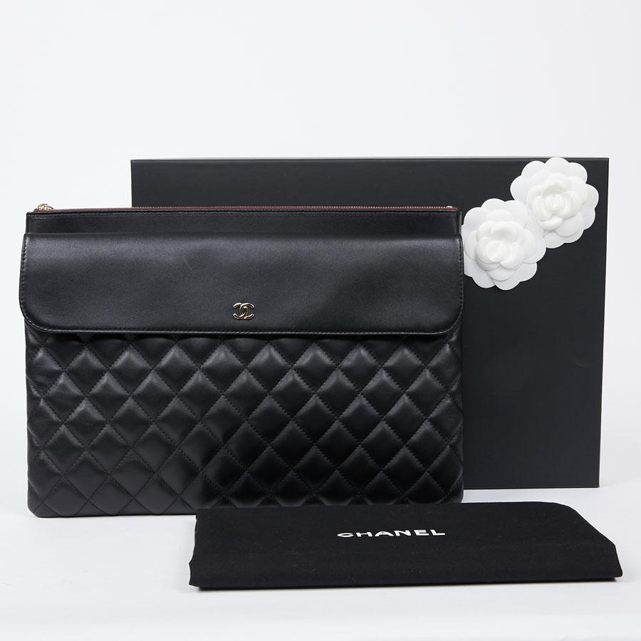 Never worn. This CHANEL clutch is in black lamb leather with quilted relief. It has different storage compartments. The main one has a zipper and the second one has a magnet embellished with a 