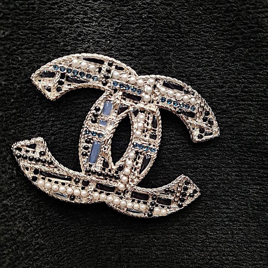 Superb! CHANEL CC brooch in large version. It is in silver metal set with pearly, black pearls and blue green rhinestones.
Condition : never been worn, it is in perfect condition. 
Dimensions: : 8x6 cm. Made in France. 2019 collection.

The brooch