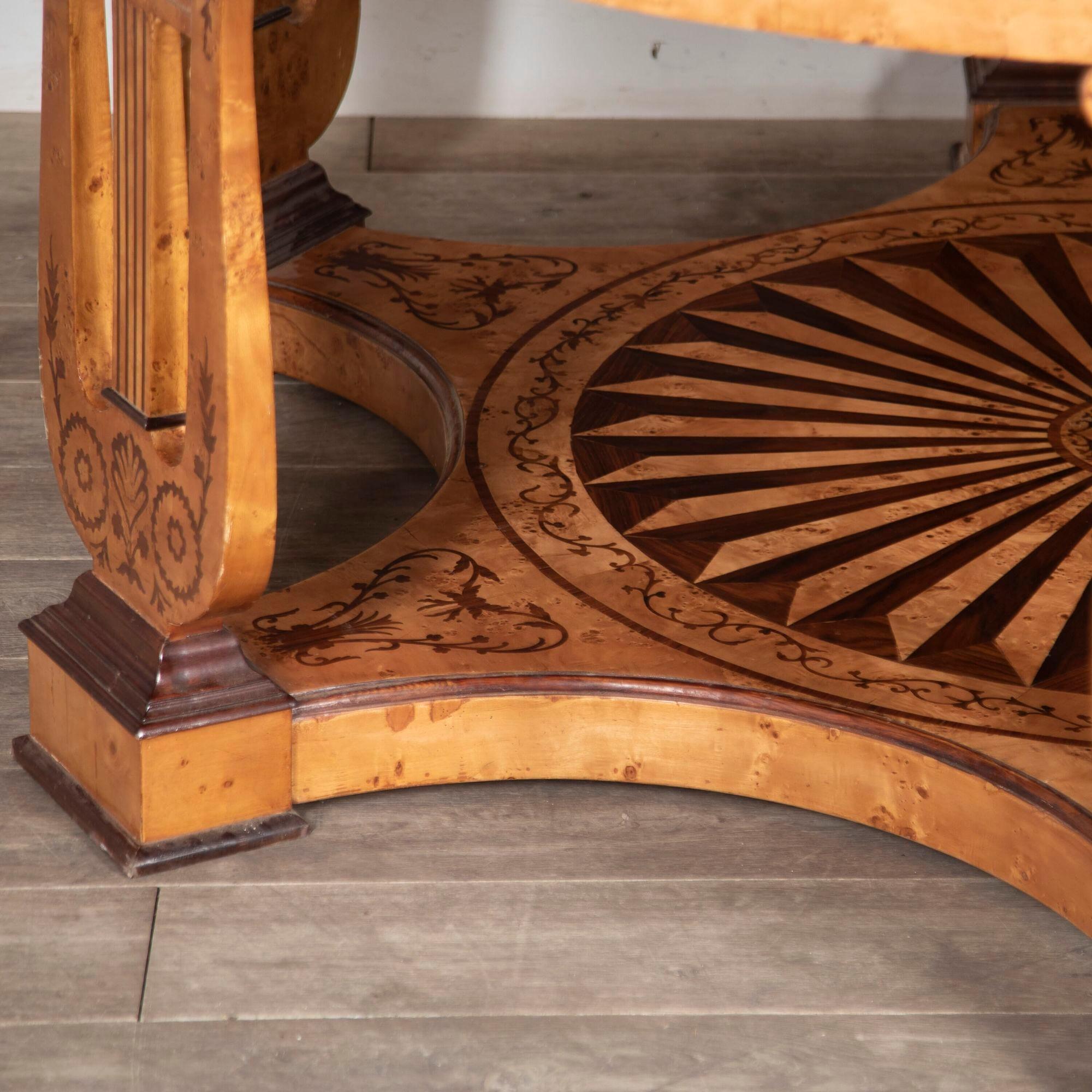 Large scale Charles X style centre table with contrasting mahogany and birds eye maple.
This table features an exceptional segmented base and six upright supports in the shape of a lyre musical instrument. This has an exceptional inlay all around
