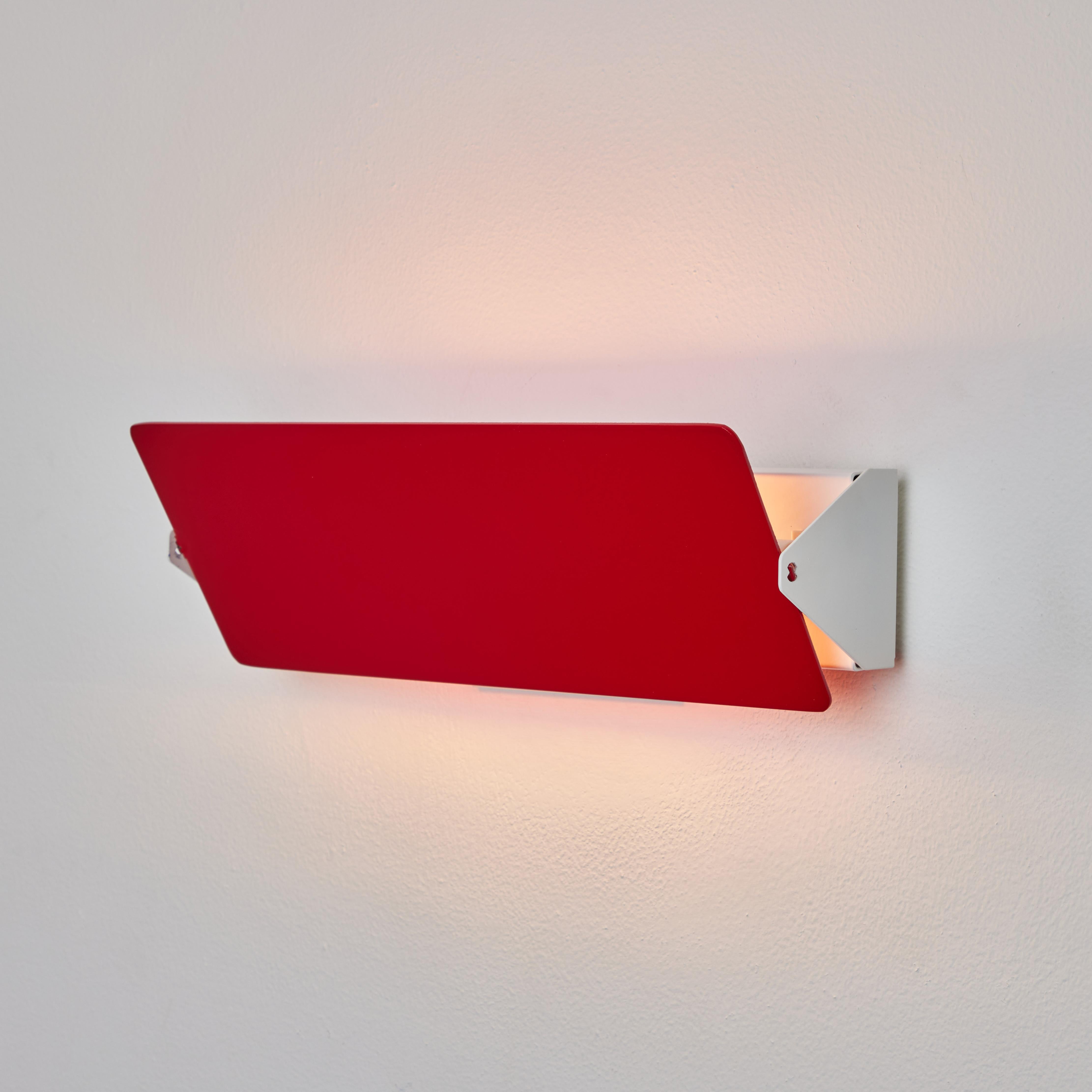 Large Charlotte Perriand 'Applique à Volet Pivotant Double' wall light in red. 

Originally designed in the 1950s as the iconic CP1, these newly produced authorized re-editions are still made in France with the highest level of integrity and