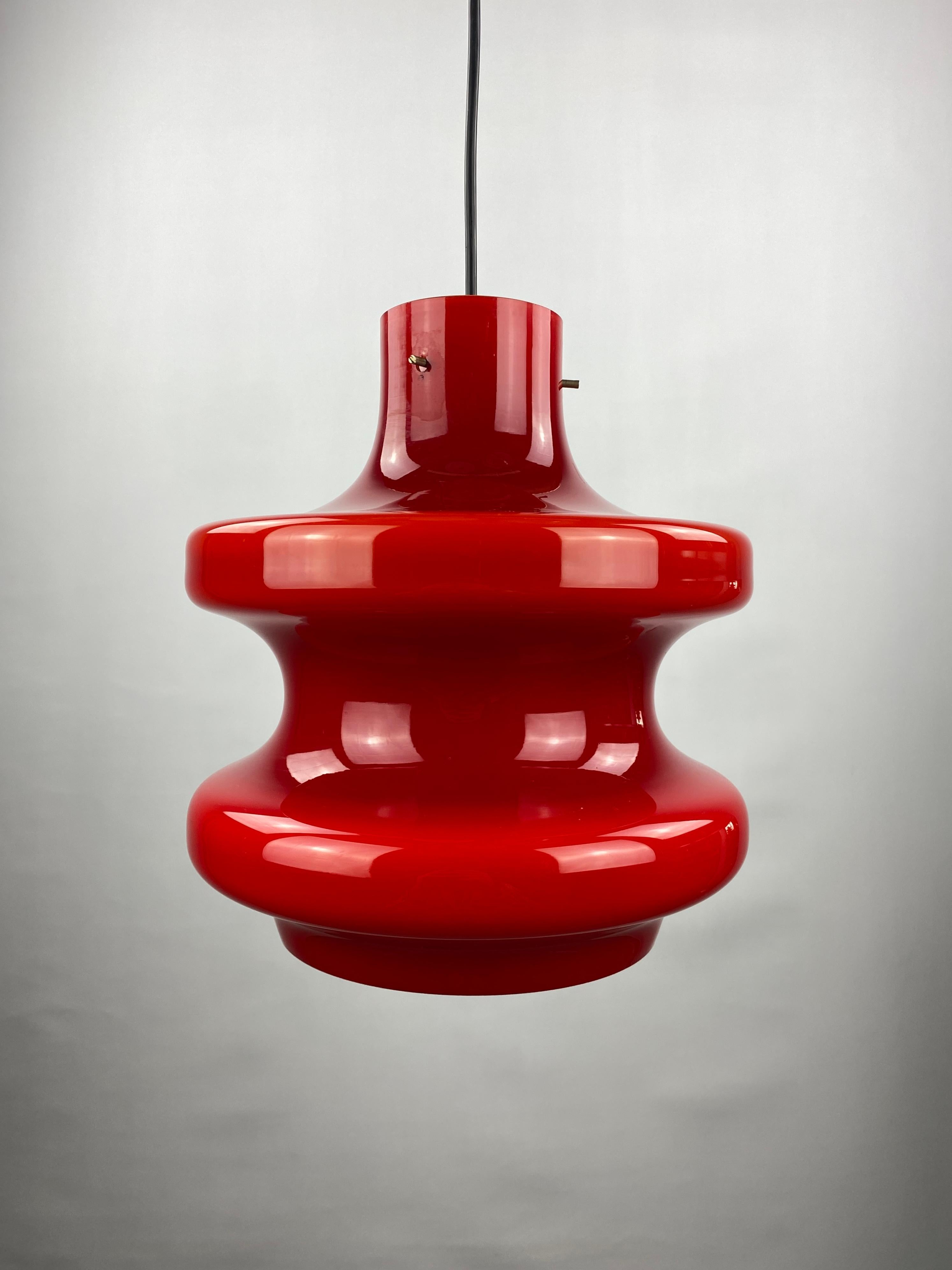 Gorgeous large dark red pendant light by Peill and Putzler, produced around 1960. Lovely cherry red color. This light is bigger than the usual models and is pretty heavy. Stays in place with the three metal pins on top.

These are Peill & Putzler's