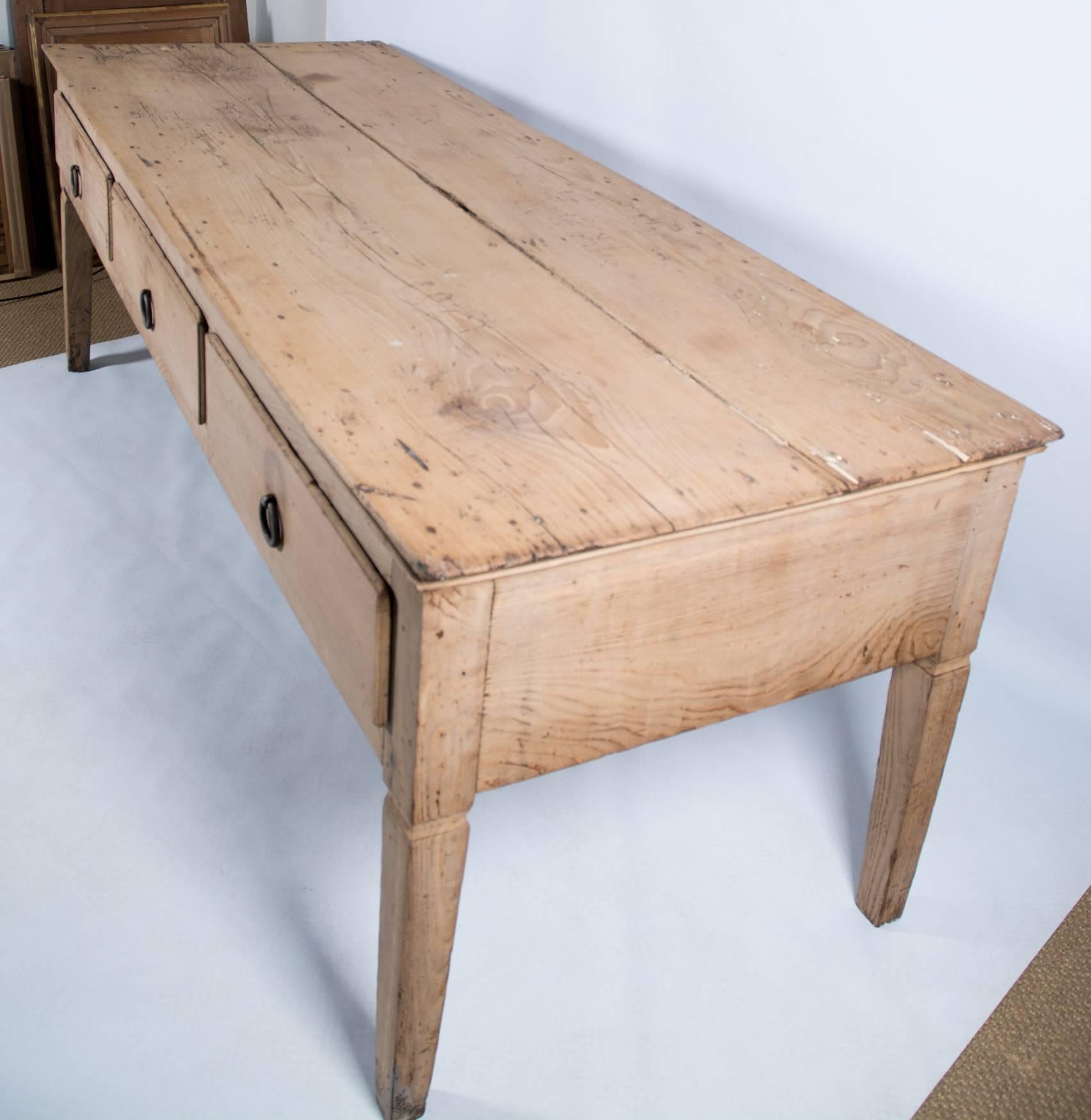 Large chestnut wood table, possibly from Portugal, Mid-18th century.
There are three large drawers to the front with iron handles.