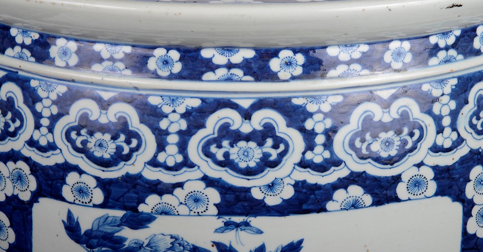 A large and impressive 19th century Chinese blue and white jardinière, having a Prunus blossom ground, floral cartouches, inset painted panels depicting exotic flowers and birds.