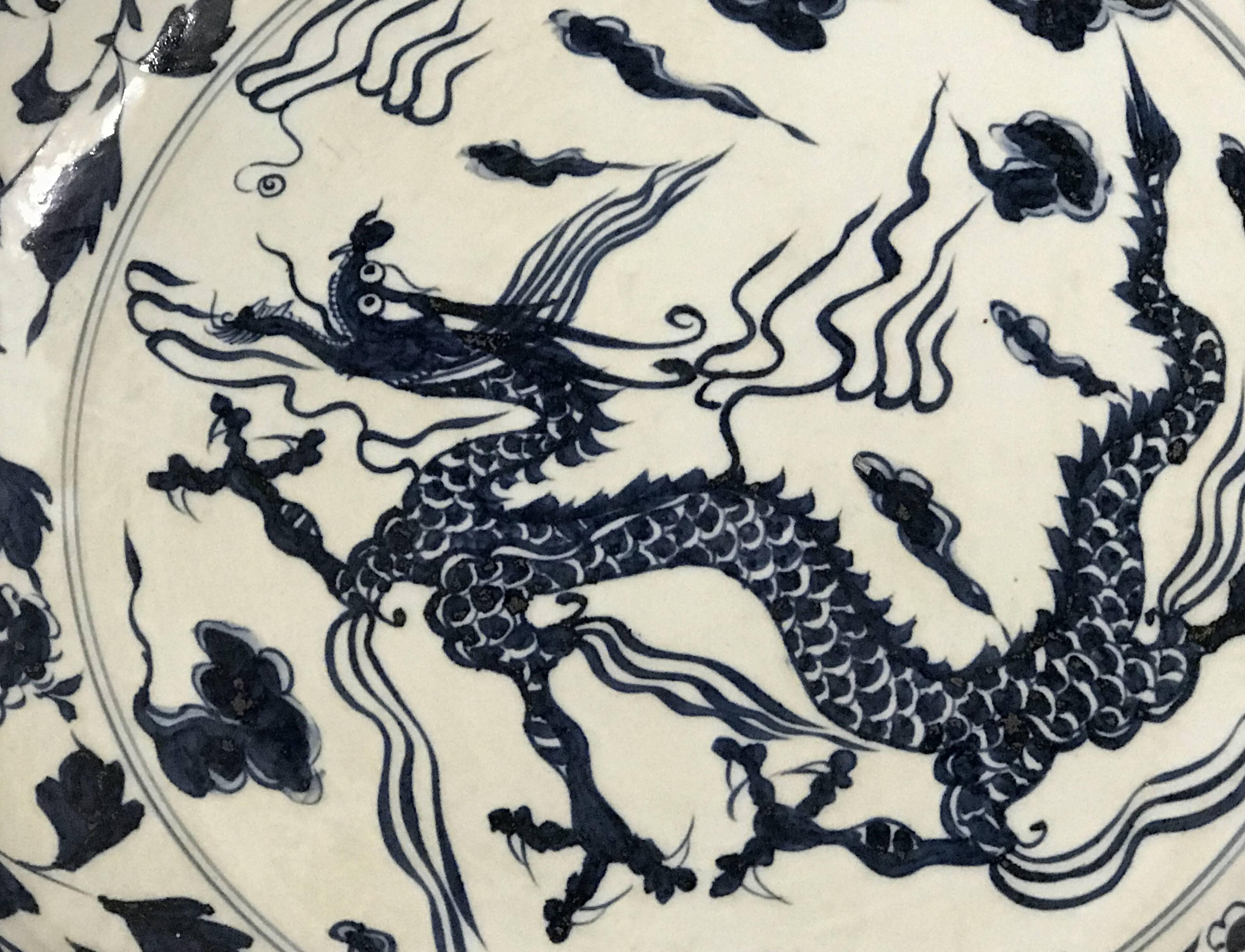 A spectacular example of a Chinese porcelain charger in blue and white with centre dragon decoration and foliate boarder, scalloped swirl decorated edge, foliate decorated underside with Xuande reign mark, probably dating to late 19th or early 20th