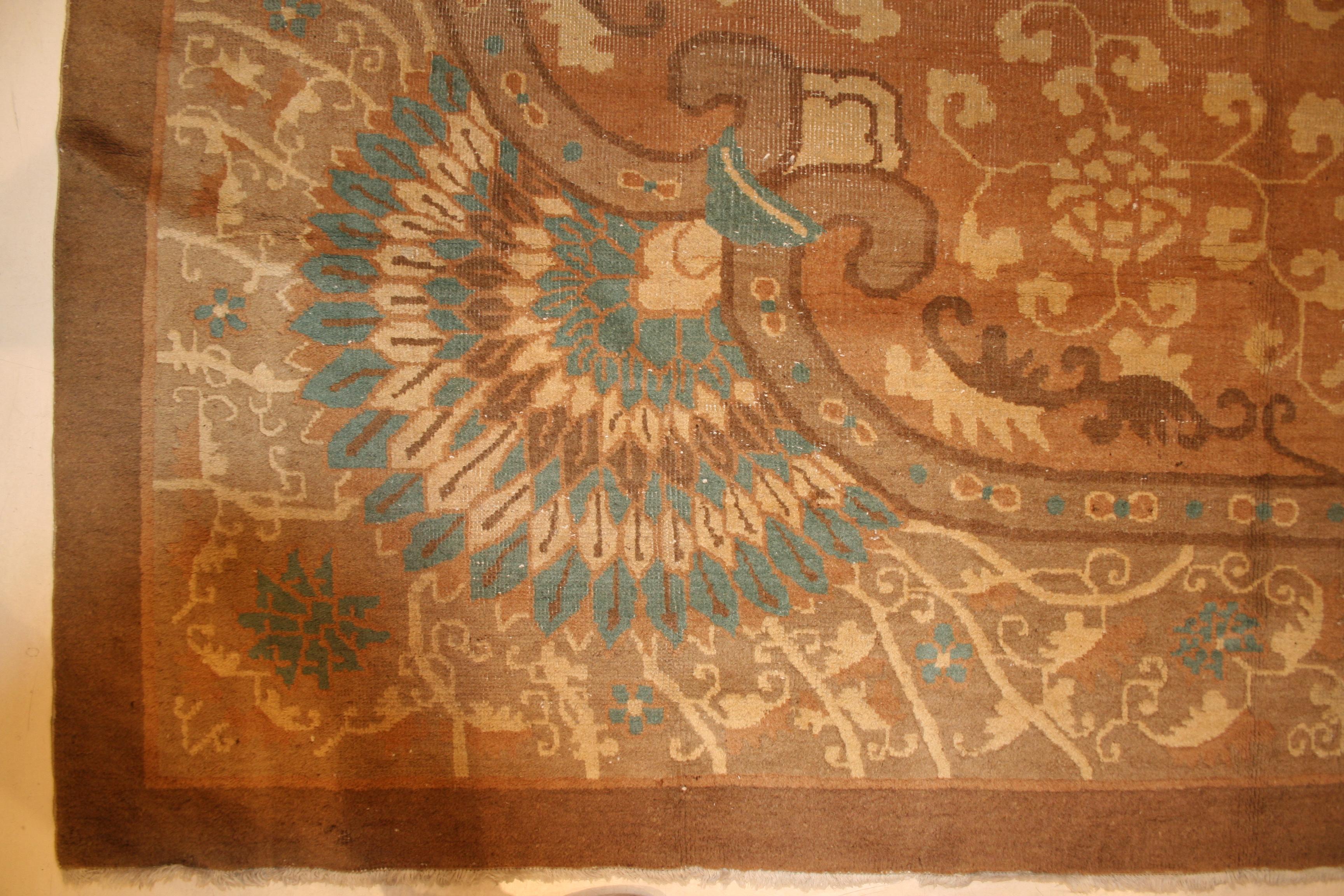 Un rare et inhabituel tapis chinois de la période Art Nouveau caractérisé par un motif de fleurs de lotus ton sur ton défilant sur un fond crème doux dans une réserve circulaire. Les éléments d'angle dérivés de paons stylisés sont typiques de