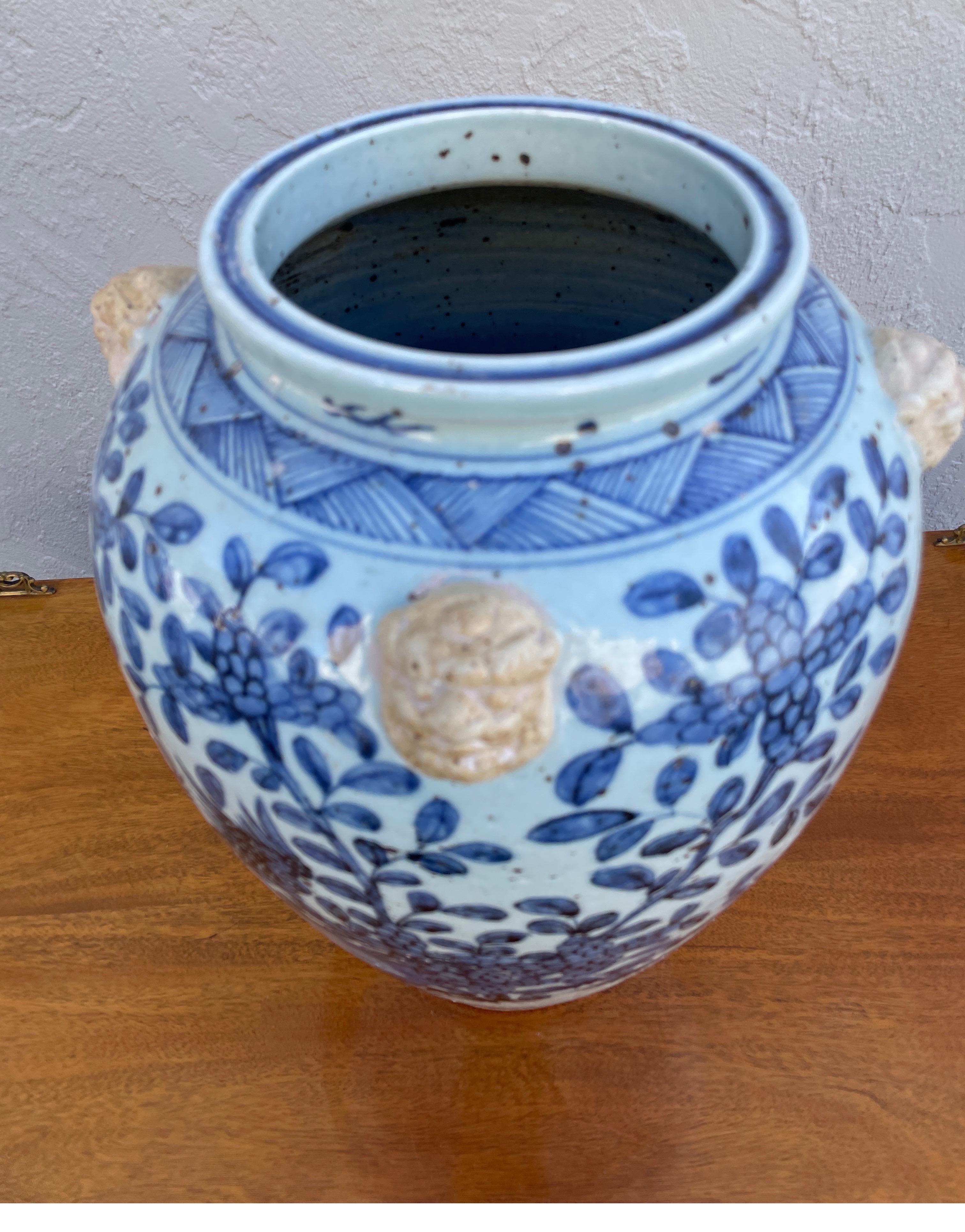 Large vintage Chinese blue and white vase adorned with four natural terra cotta foo dog heads.
