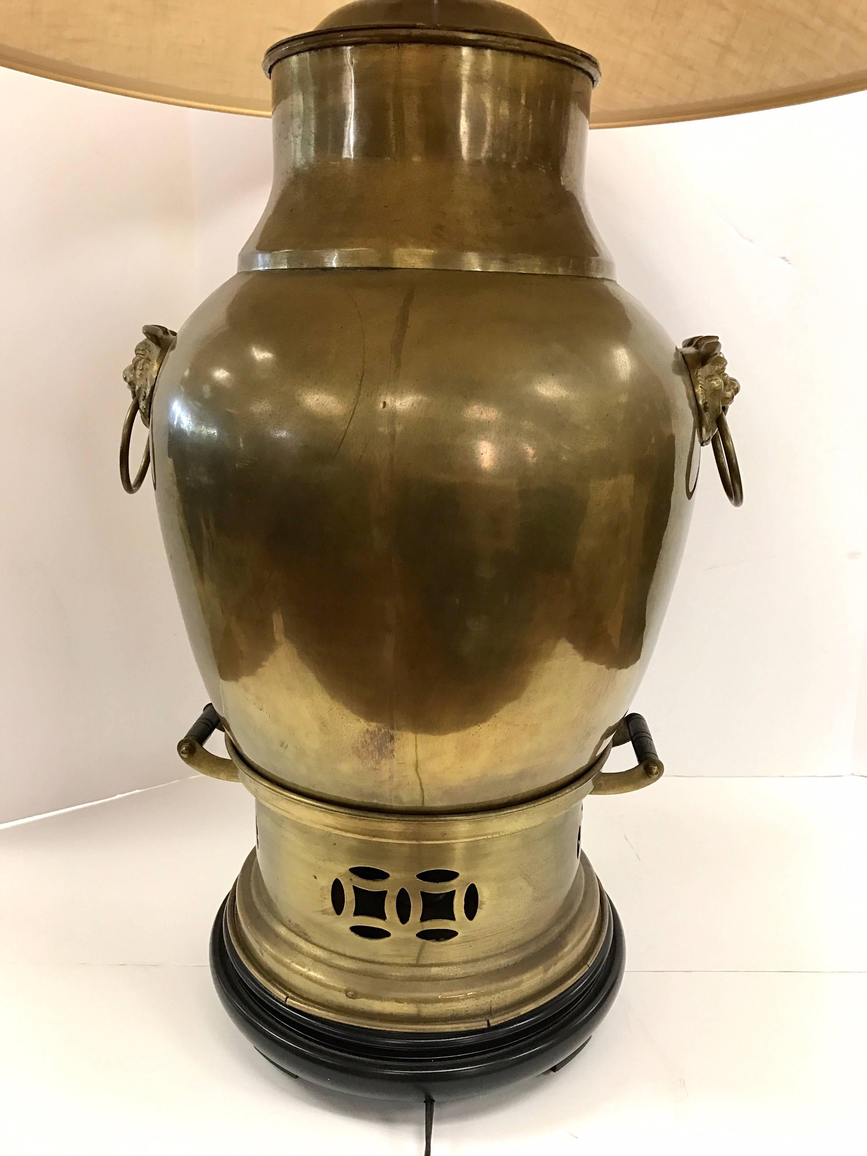 Large-scale vintage brass samovar turned into a table lamp.
The lamp has foo dog handles and is mounted on a wood stand. Wired and in working condition. Comes with linen shade which measures 23
