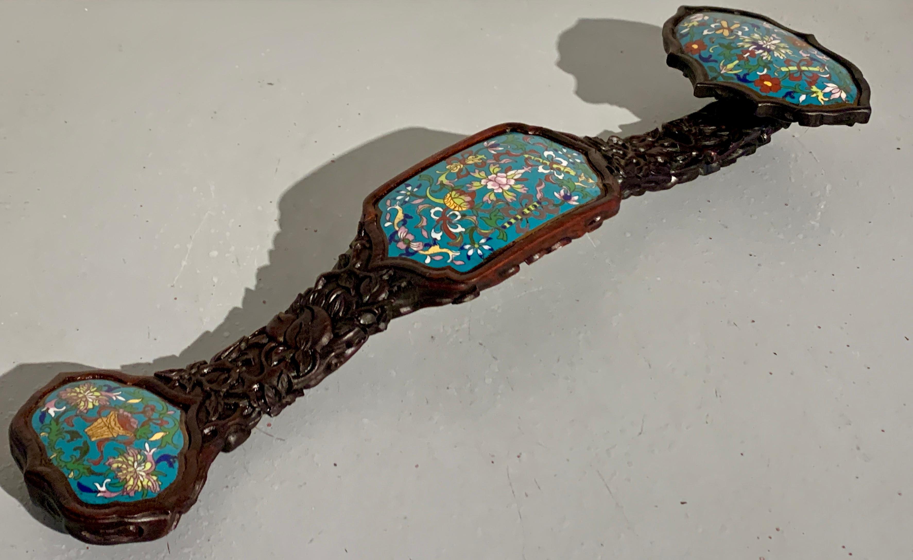 A large and impactful Chinese ruyi scepter of carved hardwood with inset cloisonne panels, Republic Period, circa 1920, China.

The large hardwood ruyi scepter of typical 