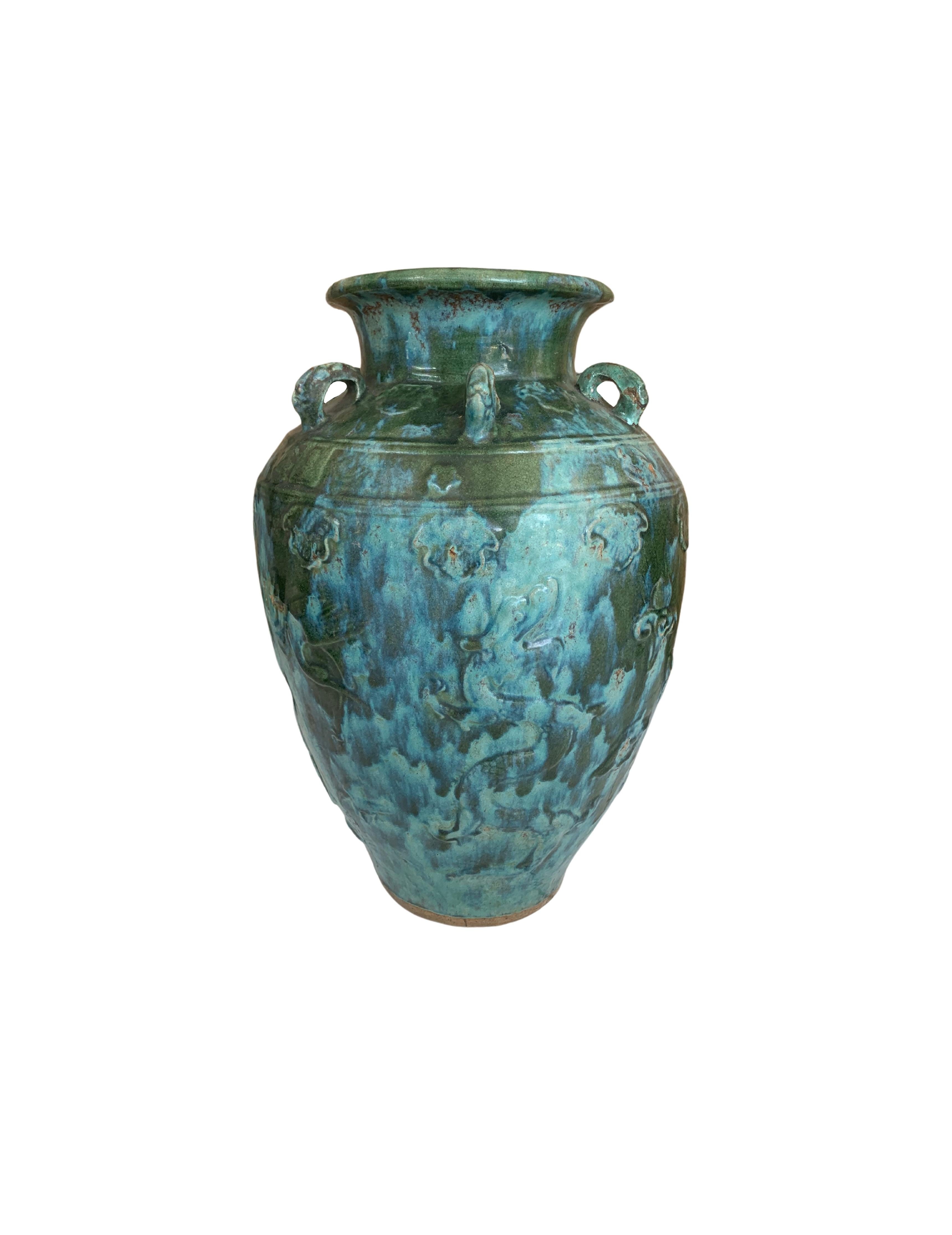 This Chinese ceramic jar features a green / blue glaze. In addition tiger medallions in the shape of loops wrap around the Jar’s shoulder. These were used to secure the lid to the jar and prevent the contents from leaking. Jars such as these