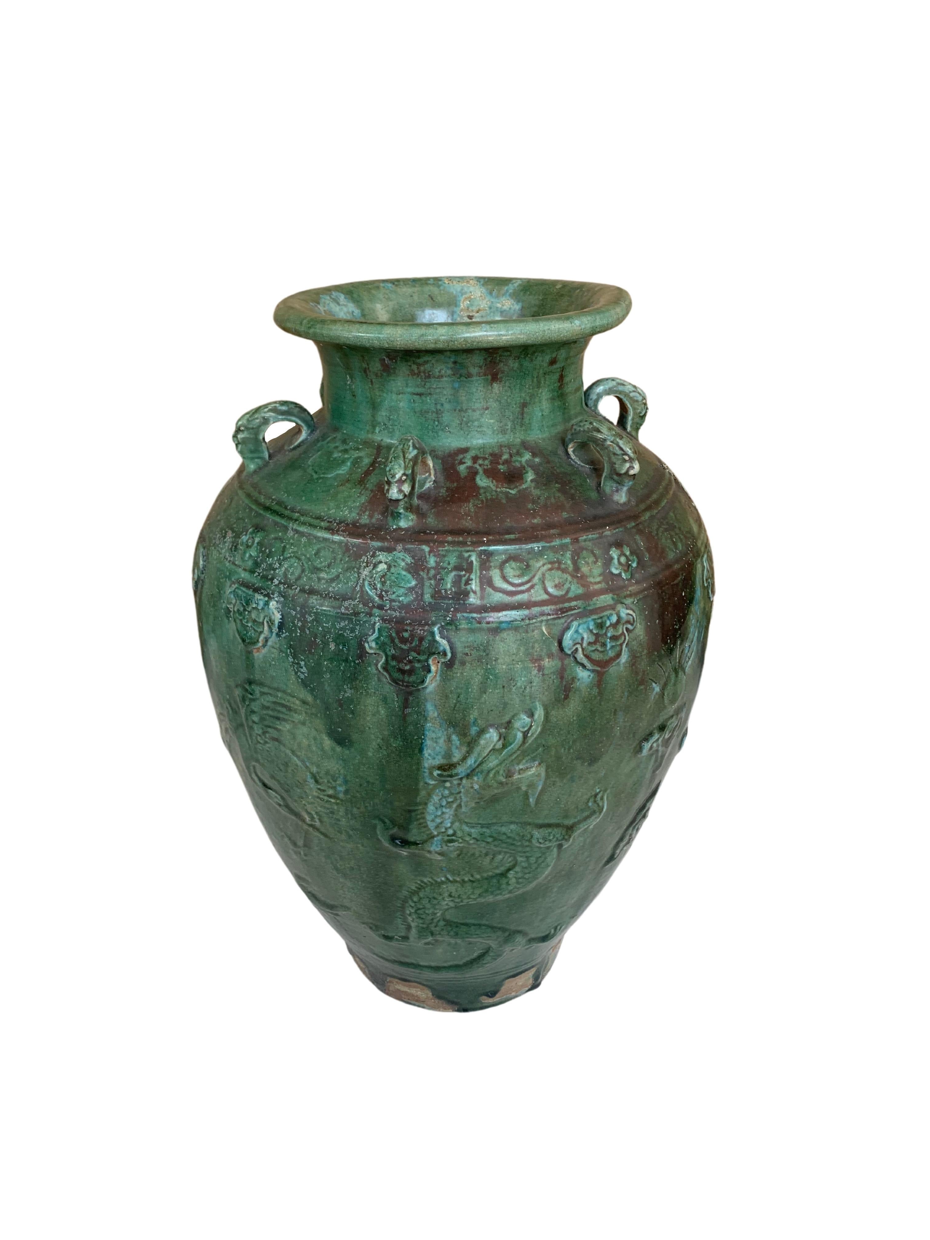 This Chinese ceramic jar features a green / blue glaze. In addition tiger medallions in the shape of loops wrap around the Jar’s shoulder. These were used to secure the lid to the jar and prevent the contents from leaking. Jars such as these