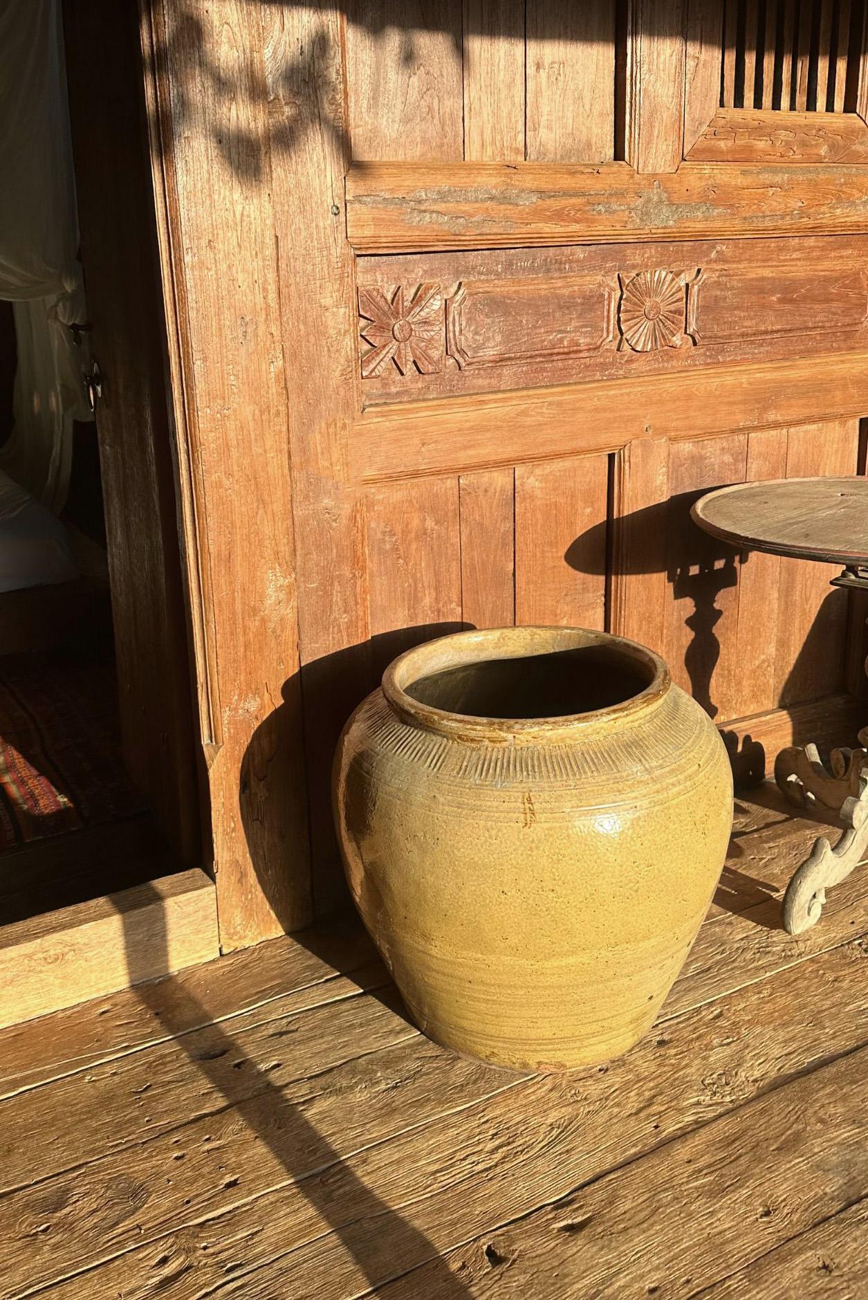 Questo grande vaso cinese in ceramica smaltata veniva usato un tempo per mettere in salamoia gli alimenti. Presenta una finitura verde giada e una superficie esterna con una texture a coste. Un grande esempio di ceramica cinese, con le sue