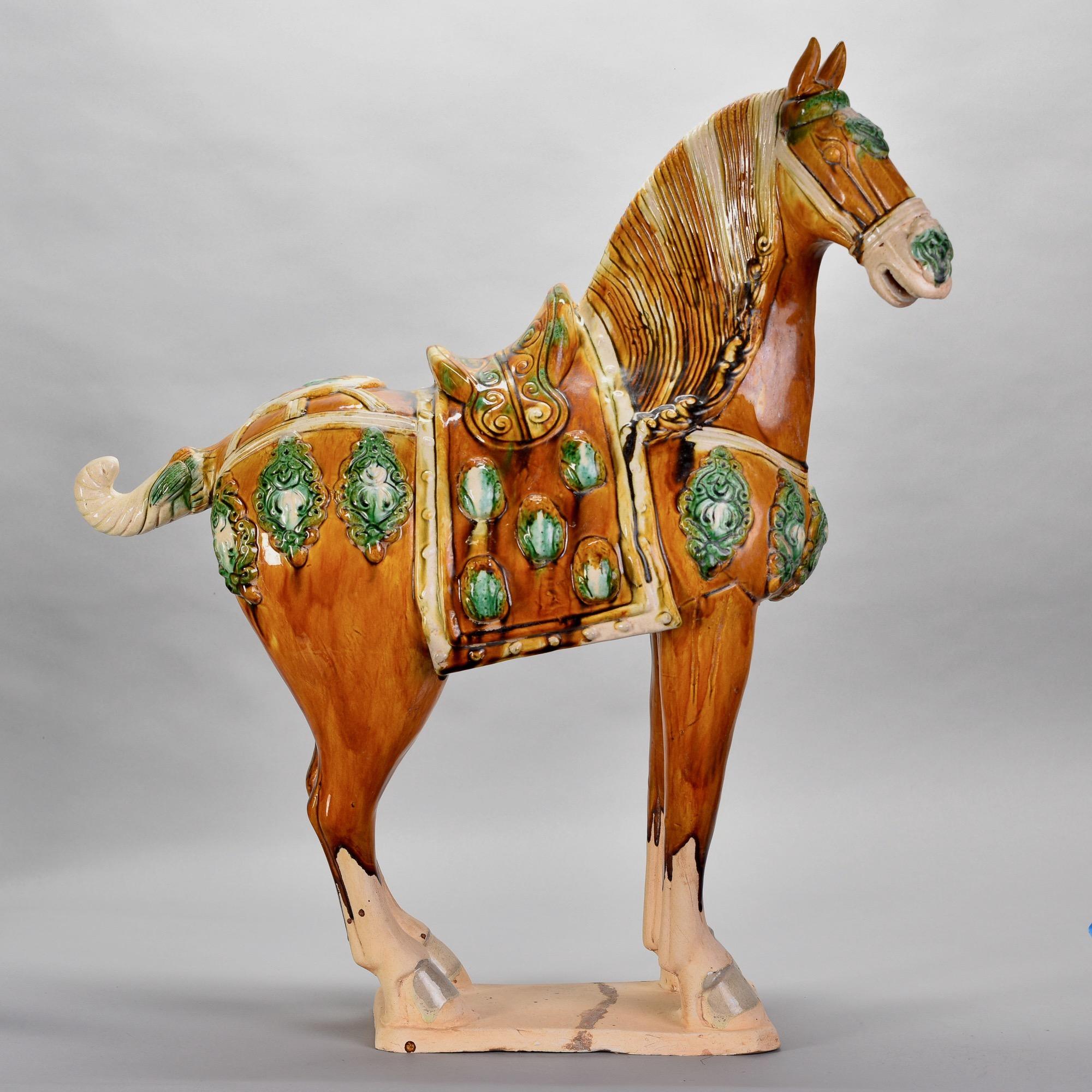 Circa 2010 Chinese ceramic Tang horse stands just under 28” tall. Colorful glaze in rich shades of amber, green and cream. Unknown maker. Very good preowned condition with no flaws found.