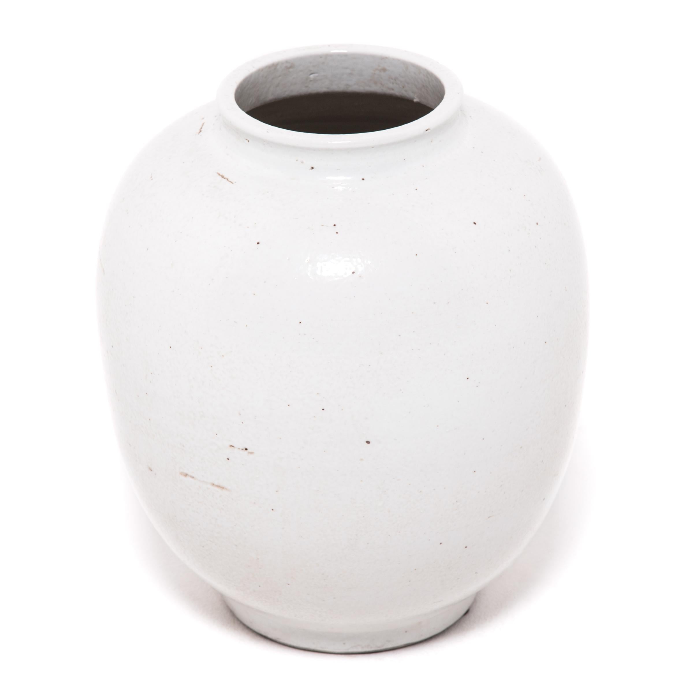 A milky white glaze emphasizes the simple, serene beauty of this contemporary ceramic. Refining the traditional onion shape, the jar has clean lines and an understated sculptural presence.