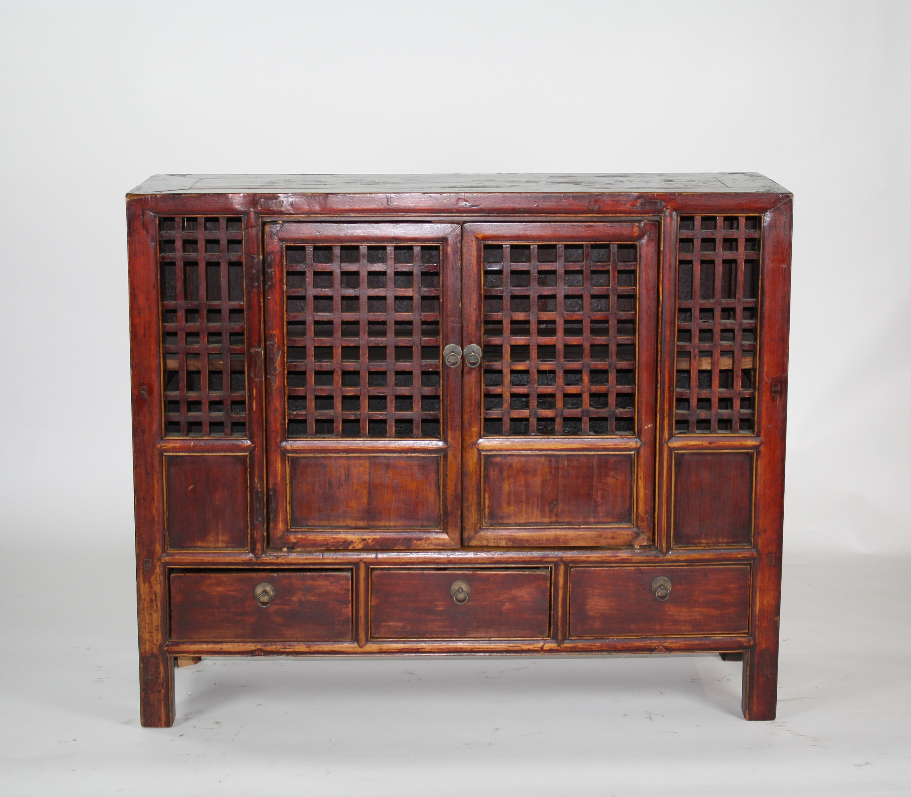 This large cabinet was once used in a provincial kitchen to store fruits and vegetables. It has open lattice doors and an open lattice back, designed to keep the stored contents fresh. The cabinet's masterful mortise and tenon construction joins the