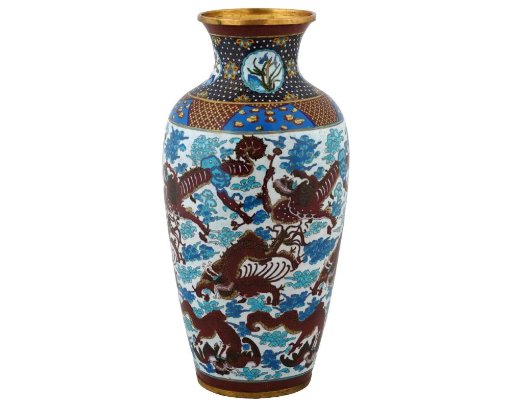 Un grande vaso cinese in ottone e smalto. Il vaso a forma di urna è ornato da un disegno in smalto policromo di draghi circondati da un ornamento a nuvola su fondo bianco realizzato con la tecnica Cloisonne. Il collo presenta medaglioni in smalto