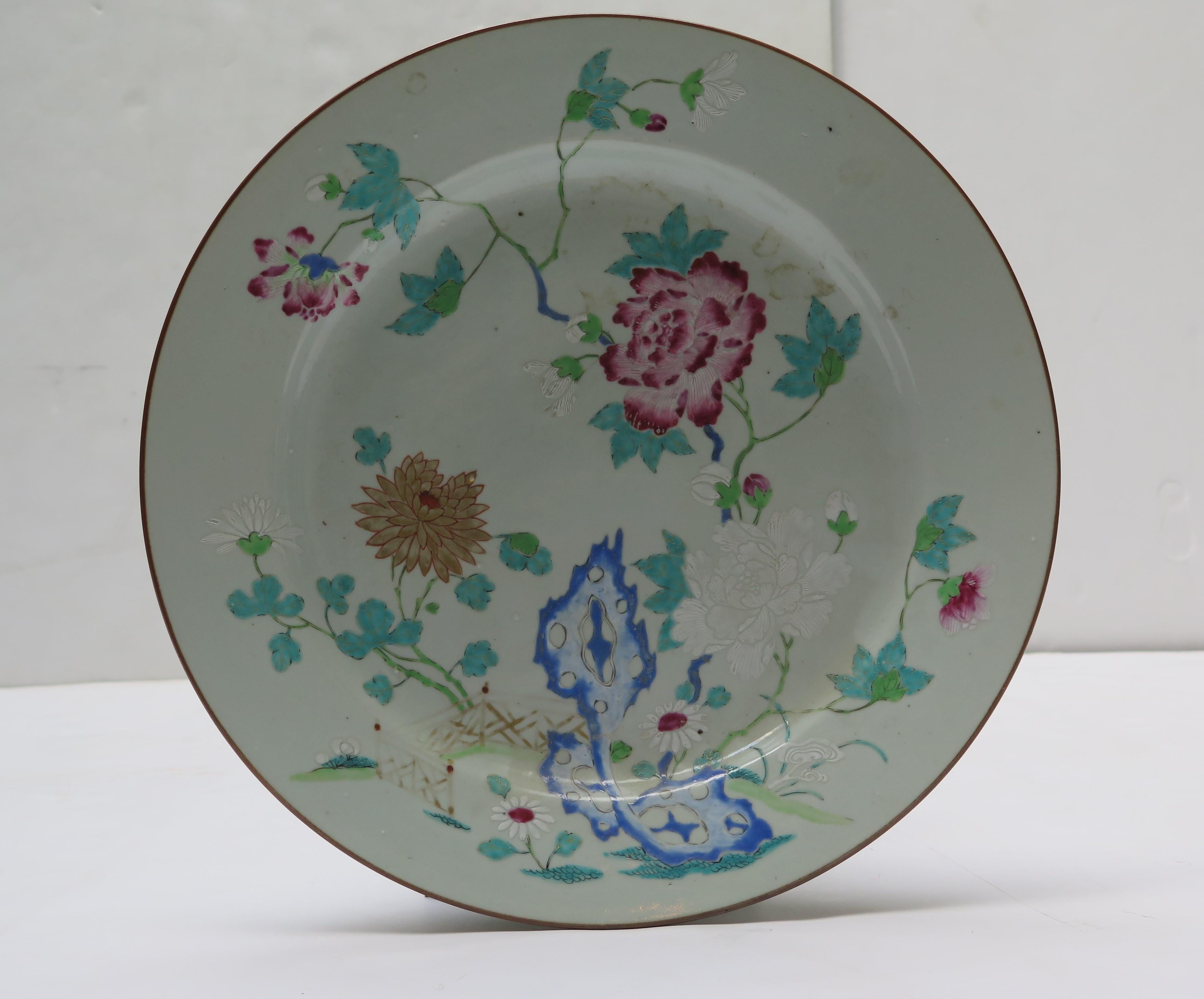 Large Chinese export famille rose plate, painted in famille rose enamels. In the center is a  chrysanthemum and peony growing from a weathered rock. 
