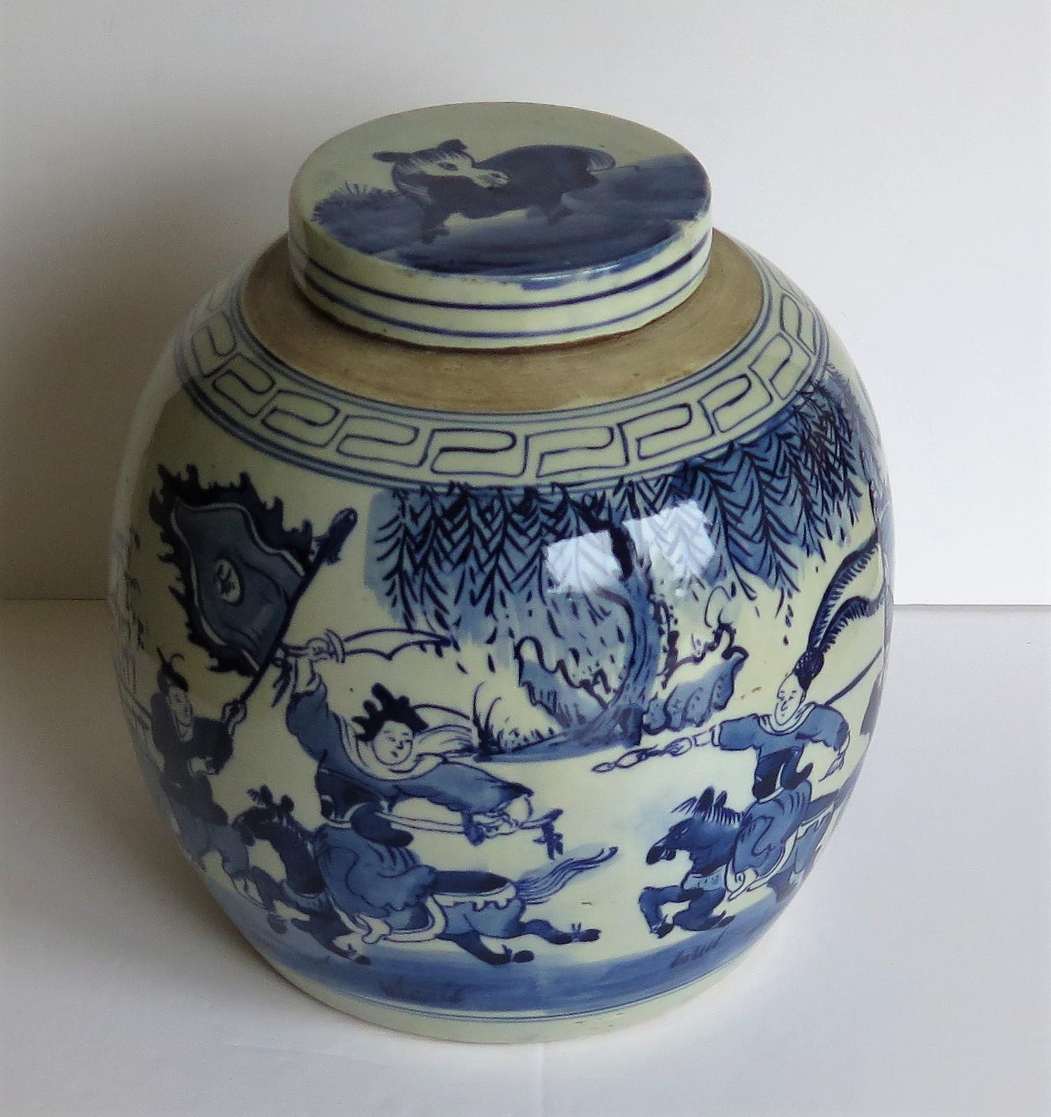 This is a large, very decorative Chinese porcelain blue and white lidded or covered jar with a hand painted scene of warriors fighting on horseback. This jar is Chinese export in the earlier Kangxi period style but dating to the mid-20th