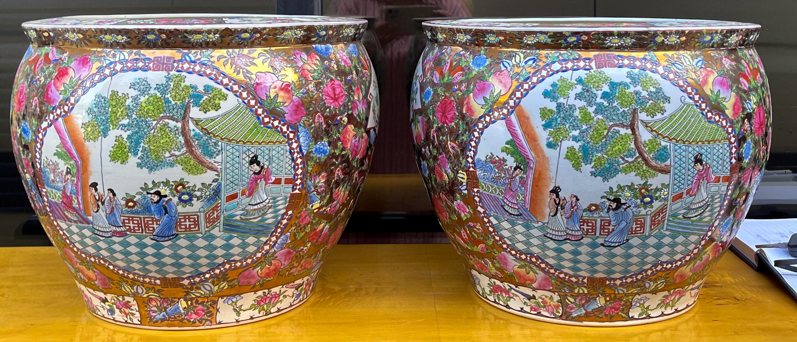 This is a pair of large Chinese Famille Rose style planters. They are hand painted and lined with swimming koi fish. The body is painted with fruit and pastoral scenes. They are in very good condition.