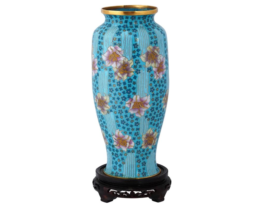 A large rare Chinese enamel over brass vase. The unusual shaped vase is adorned with polychrome images of flowers surrounded by floral and wavy motifs against a bright turquoise background made in the Cloisonne technique. Completed with a footed