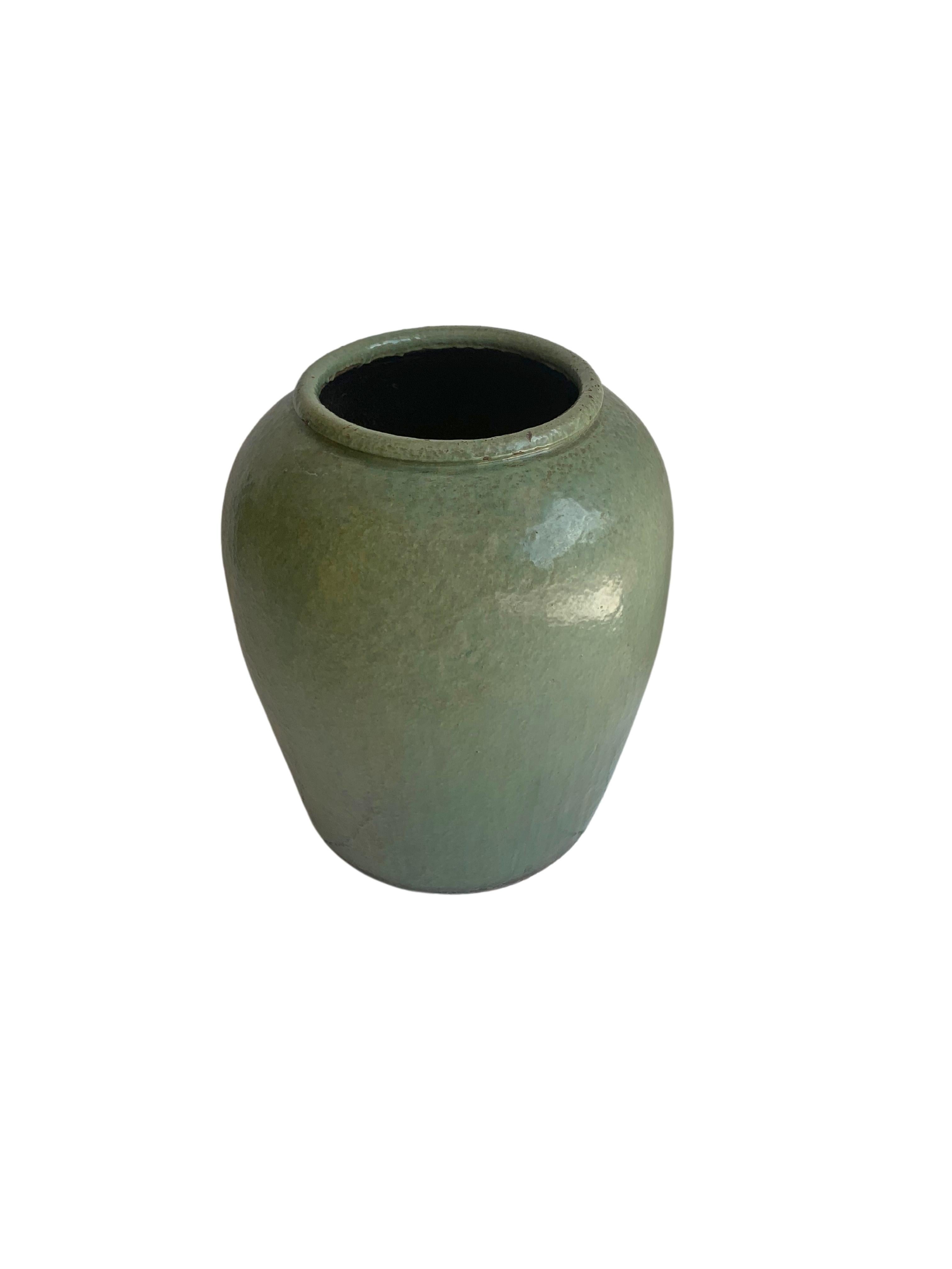 This large glazed Chinese ceramic jar from the turn of mid 20th Century was once used for pickling various foods. It features a wonderful green / turquoise glazed finish and outer surface. A great example of Chinese pottery, its neutral colours make