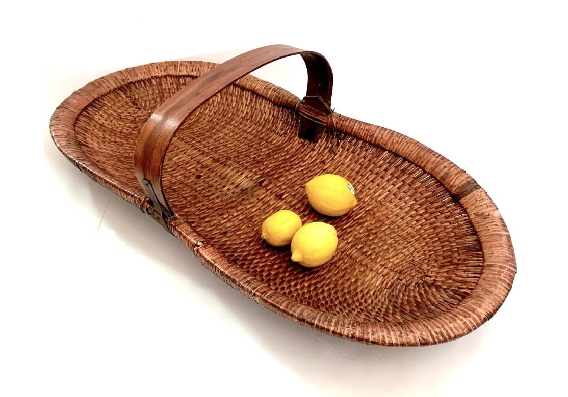 A large and very decorative Chinese hand woven market flower basket with single center handle, cinched center and an over-cast edge stitch.

Dimensions: 34 1/8