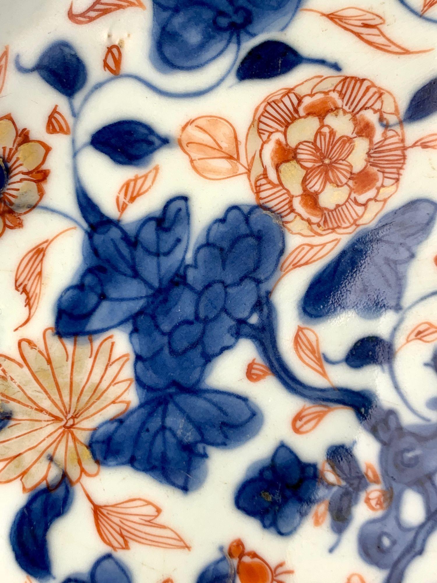 This large Chinese Imari porcelain charger dates to the Qianlong period of the Qing dynasty, circa 1760.   Finely potted with a lovely rich, glassy white glaze, the charger is hand-painted in a vivid Imari palette of orange-red, cobalt blue, and