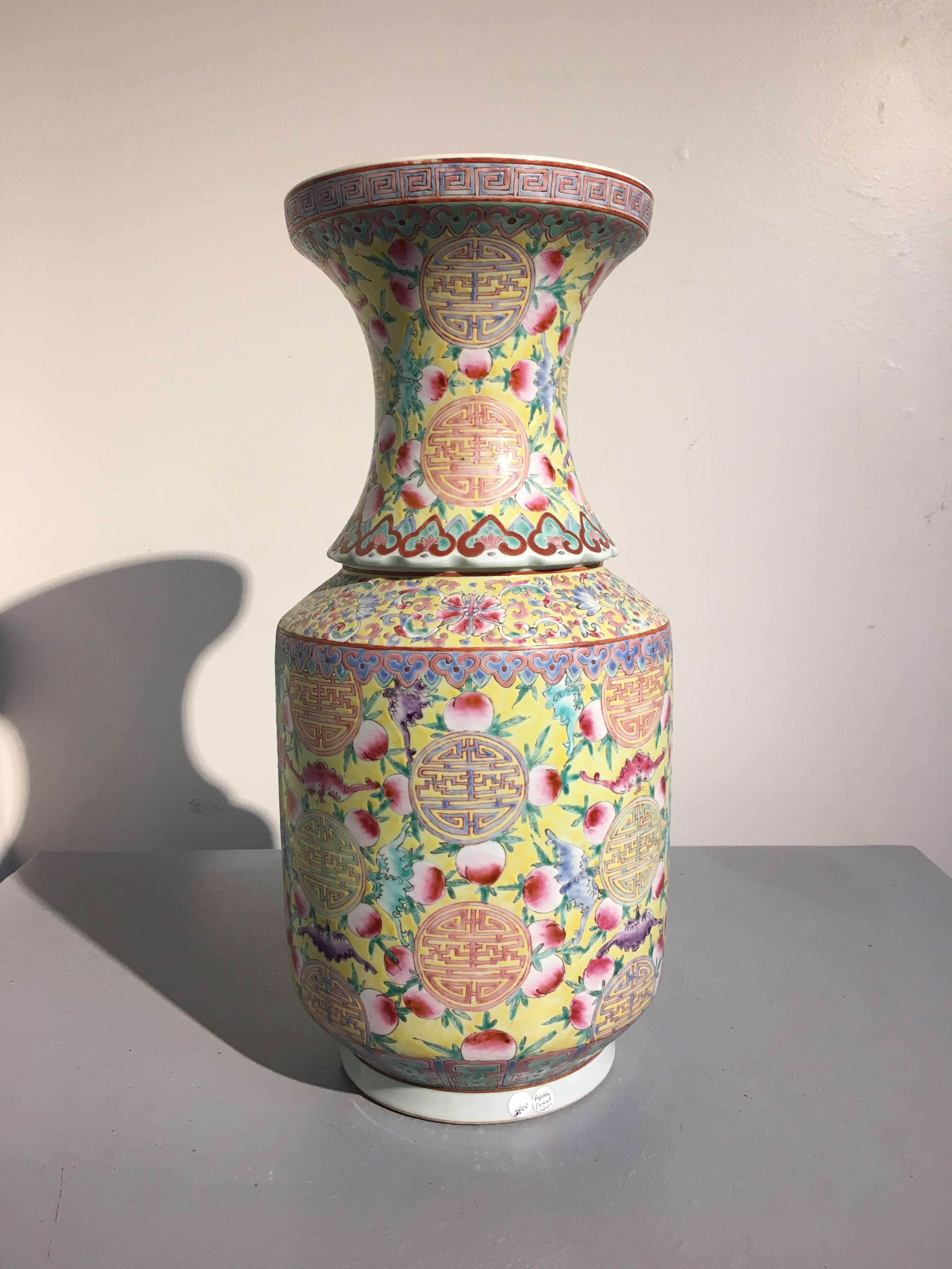 A large Chinese famille rose et jaune porcelain vase, with a six character Da Qing Guangxu Nian Zhi mark, but late Republic Period, circa 1940. 
Of unusual form, the tall vase is molded in two parts, with a tall cylindrical body resting on a high,