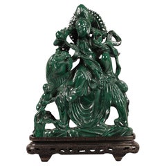 large Chinese malachite carving of a deity sitting on top of a lion