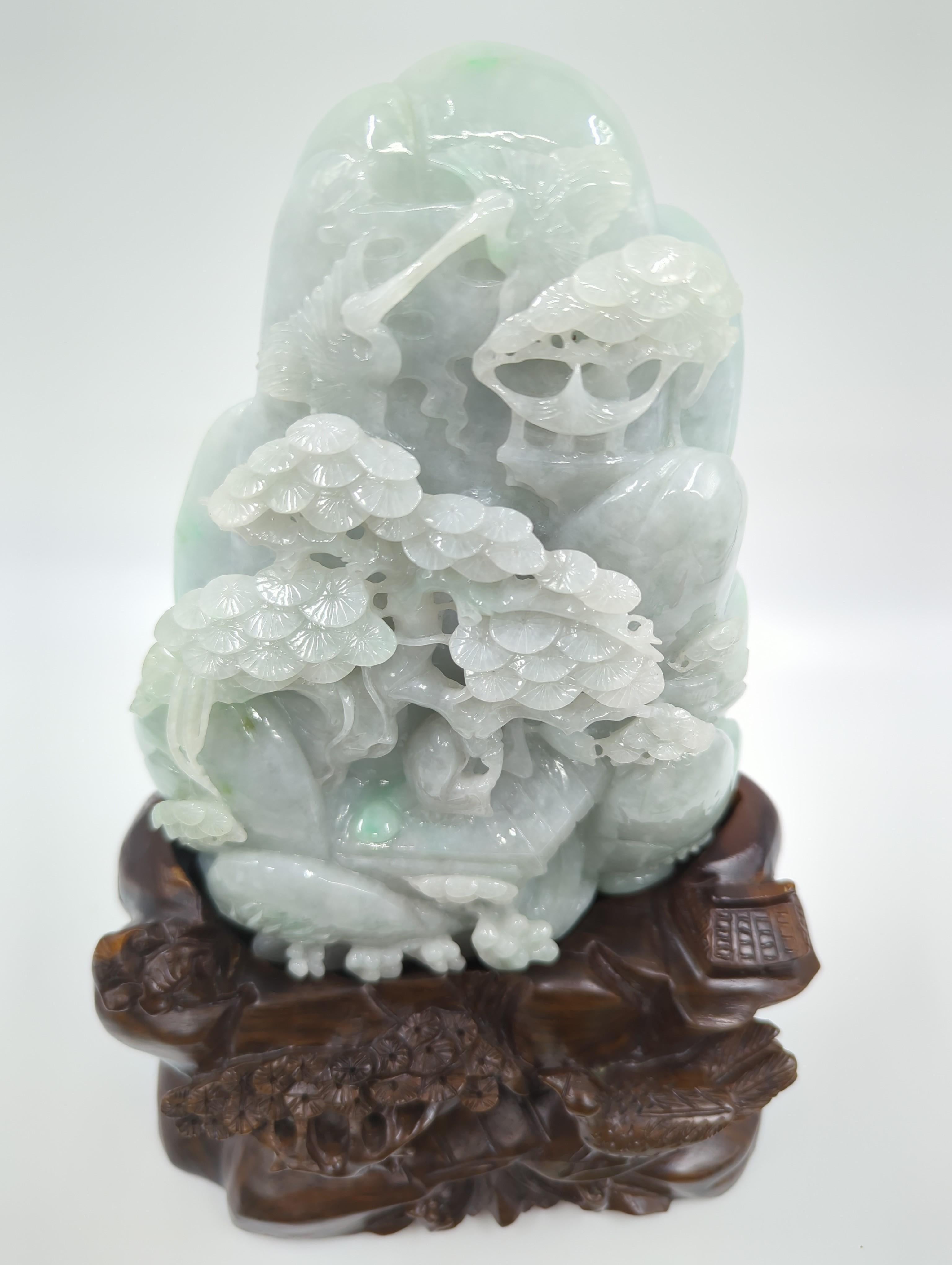 This modern Chinese jadeite mountain, standing at an impressive 18 inches on its stand, is a remarkable piece of artistry, showcasing the exquisite craftsmanship associated with contemporary Chinese jade carving. The highly polished carving depicts