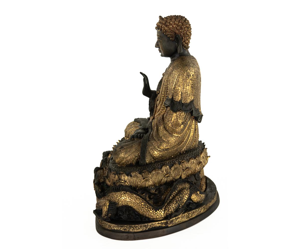 Offered is this fabulous Chinese gilt bronze Buddha in seated comfortably on a lotus flower which rests upon two dragons that are facing a pearl. The workmanship of the casting a gilt work is fabulous as the entire surface is textured throughout the