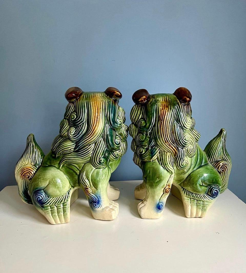Vintage Pair of Ceramic Glaze Polychrome Chinese foo dog sculptures. Features a color palette of cream, green blue and brown.
this pair has a substantial size that could be use on a fireplace mantle or entry table. Colors are rich and vibrant 