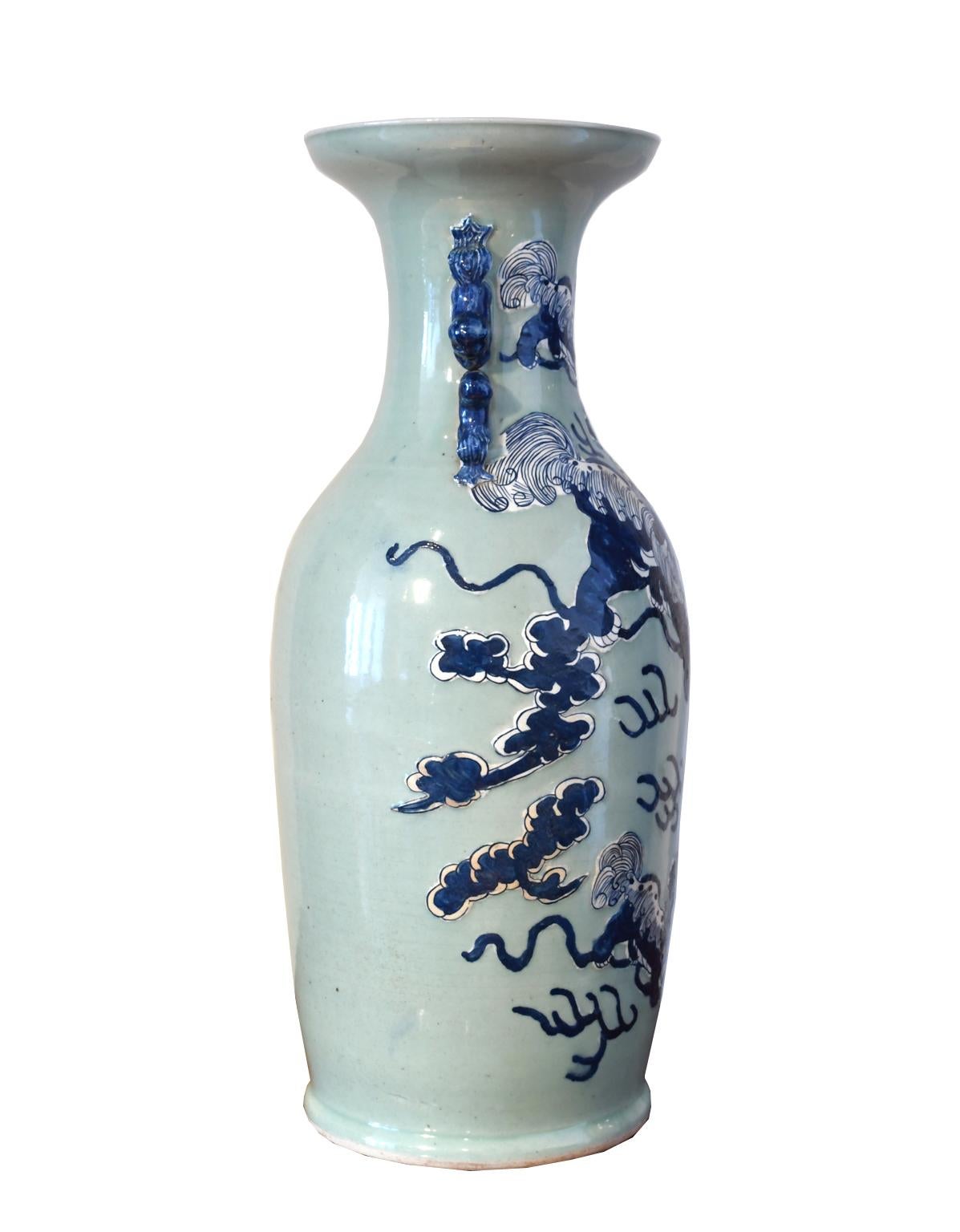 A very handsome and large Chinese porcelain vase with foo dog handles, with blue underglaze and hand-painted cobalt blue and white decorations depicting foo dogs or shi lions playing with a ball that has the 