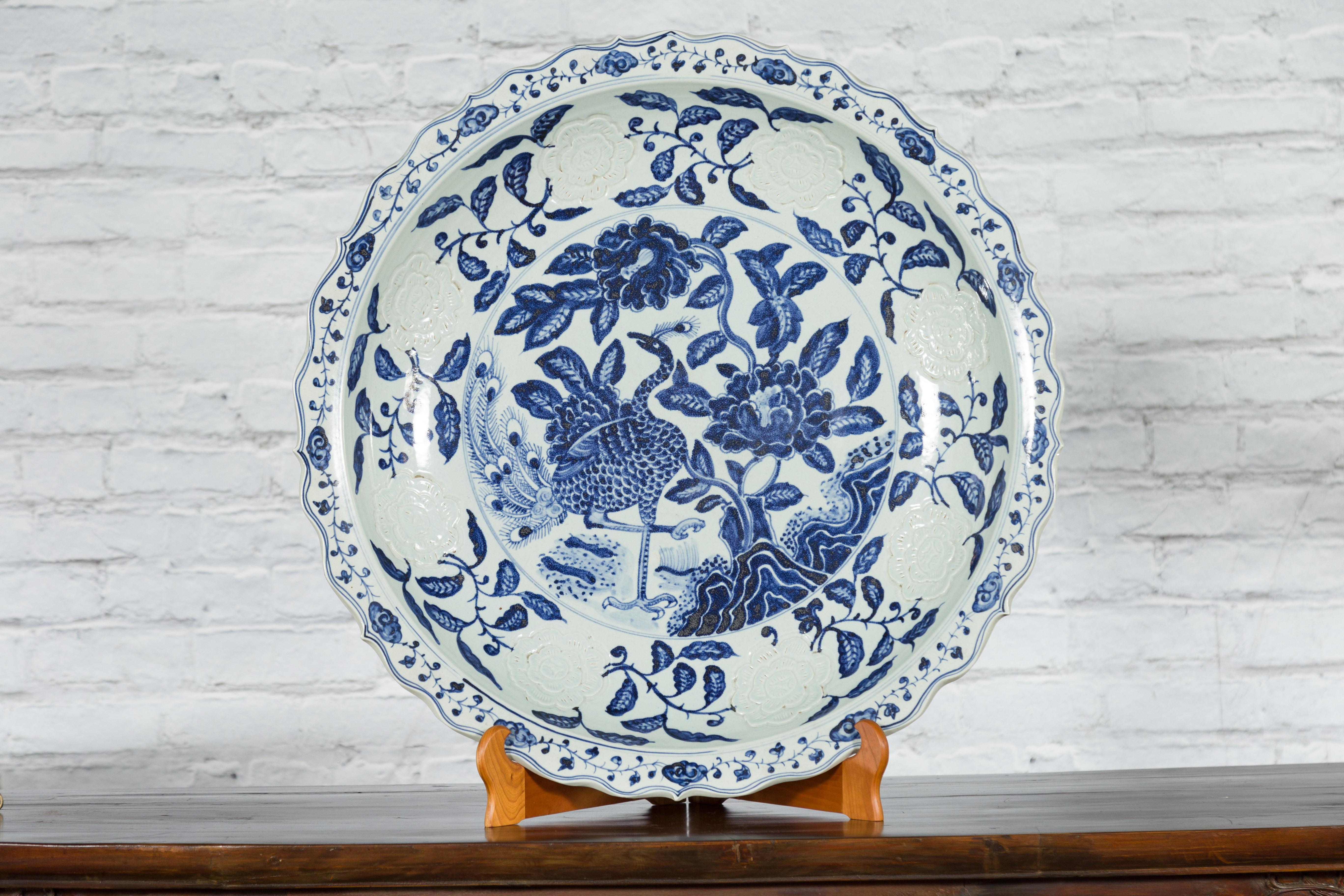 A large Chinese porcelain charger plate from the early 20th century, with hand-painted blue and white décor. Created in China during the early years of the 20th century, this large charger will make for a lovely decorative accentuation. The charger