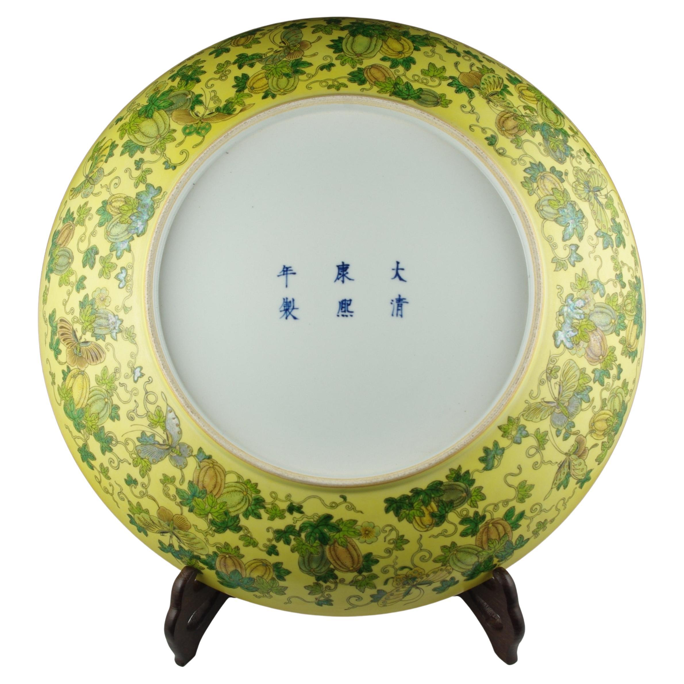 A large Chinese famille jeune porcelain charger, finely hand decorated in sancai with  a center medallion and a band of melons on vines and foliage. This impressive charger measures 16.75