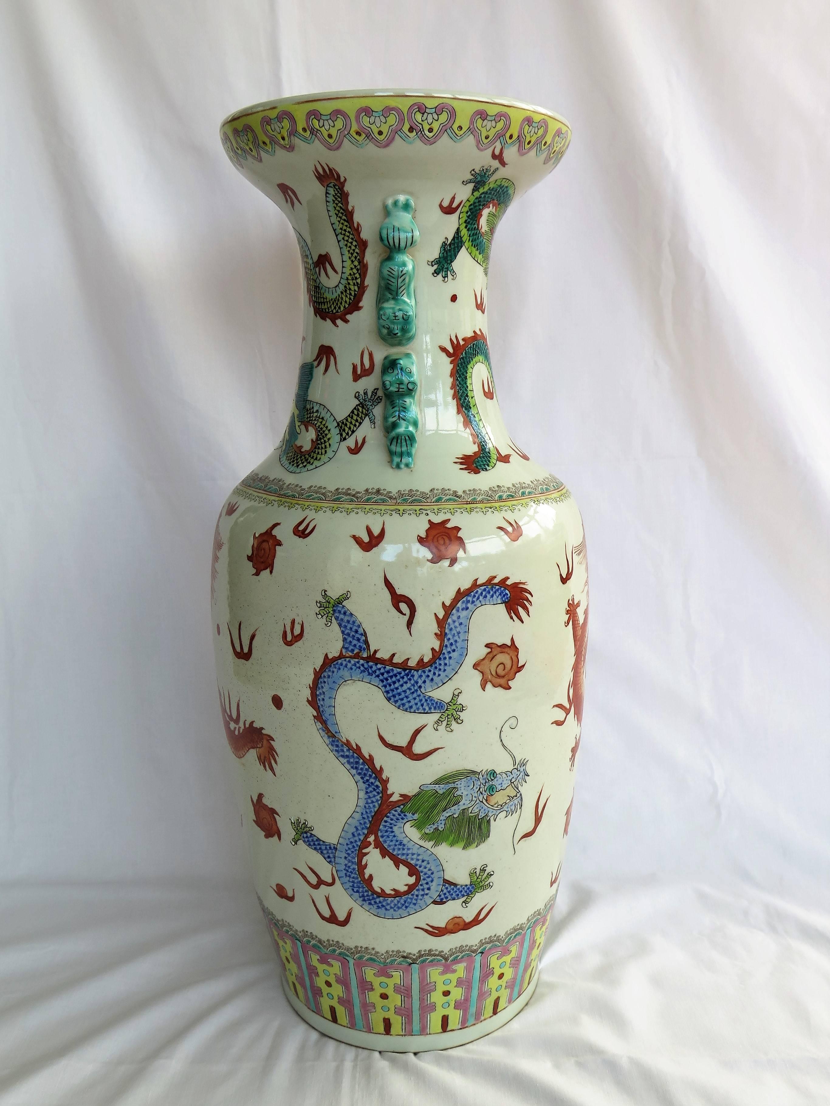 This is a very decorative, large, hand painted, Chinese porcelain Floor Vase dating to the early 20th century, circa 1920.

The vase has a baluster shape with a flared open neck rim, with four climbing foo dogs at the neck, two either side. 

The