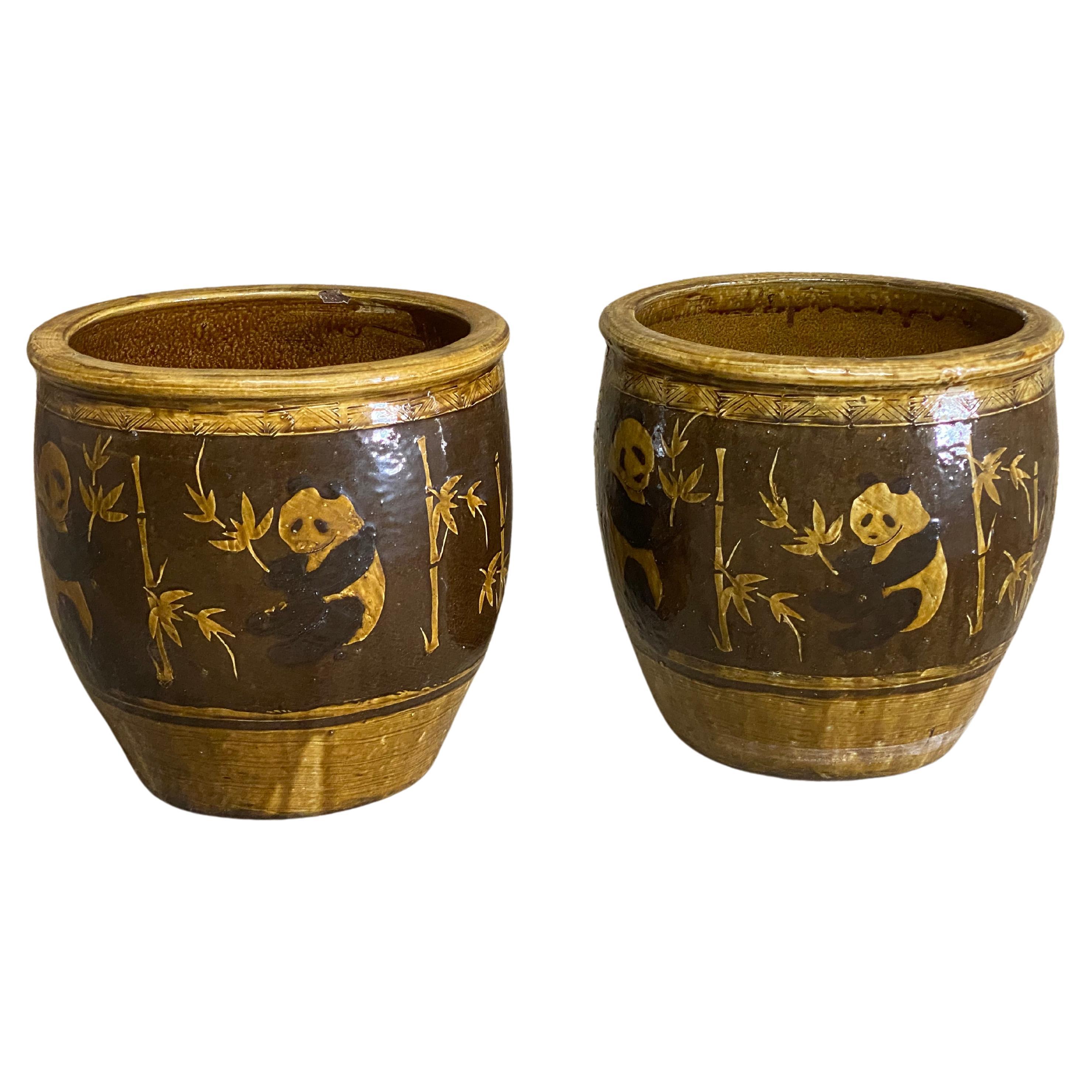 A pair of beautiful and large Chinese standard glazed panda bear and bamboo decorated red clay planters. Circa 1970-80. Both pots are hand decorated in the round of lovable and cuddly panda bears in various positions. Geometric design on the rim