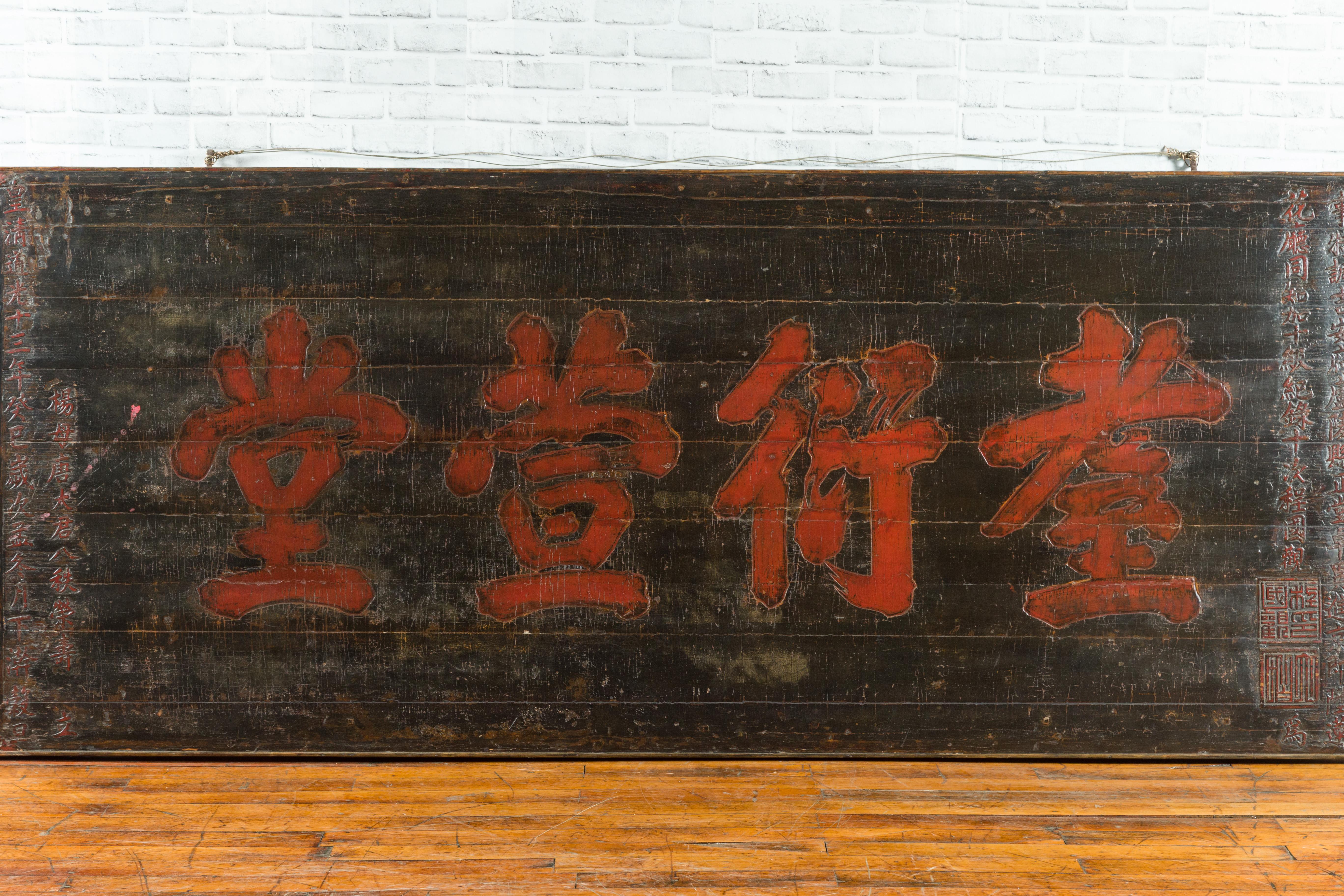 Ein großes schwarzes Schild aus der chinesischen Qing-Dynastie aus dem 19. Jahrhundert mit roter Kalligrafie. Dieses große horizontale Schild aus der Qing-Dynastie stammt aus einem chinesischen Tempel und zeigt sowohl geschnitzte als auch gemalte