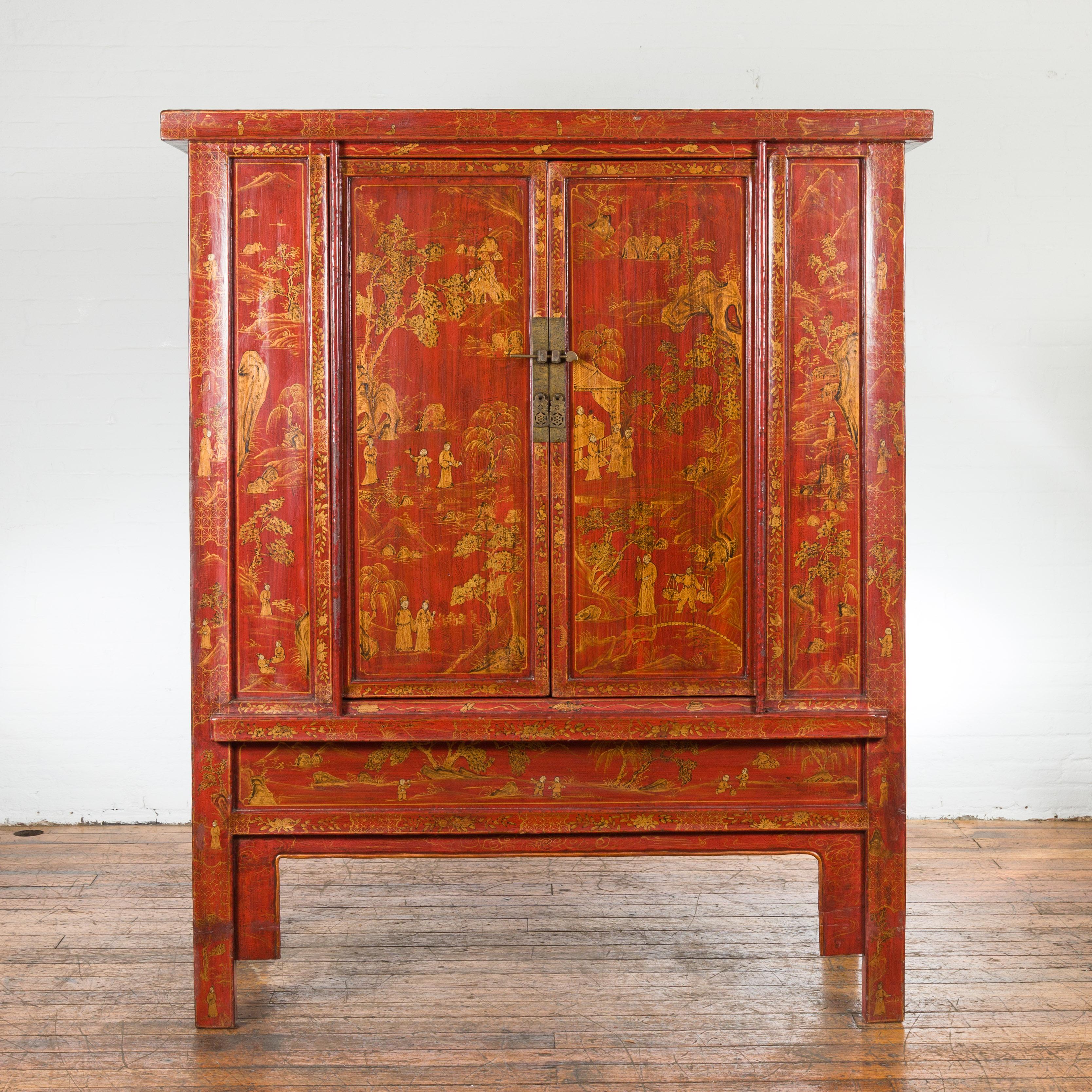 A Chinese Qing Dynasty period large armoire from the 19th century with red lacquer, gilt décor, two doors and front apron. Created in China during the Qing Dynasty period in the 19th century, this large armoire features a linear silhouette perfectly