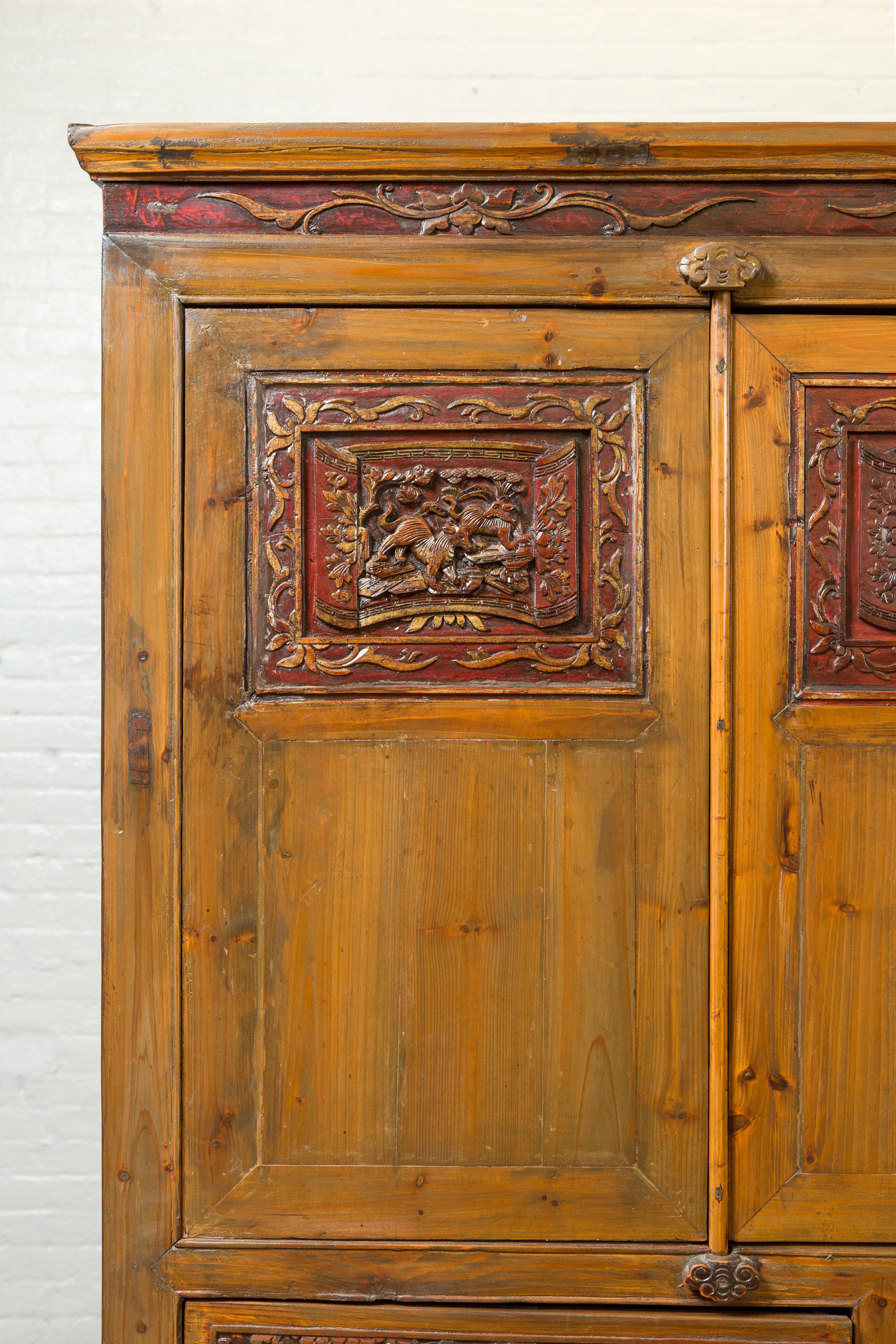 Sculpté à la main Grande armoire chinoise Qing en orme avec motifs sculptés et accents laqués rouges en vente