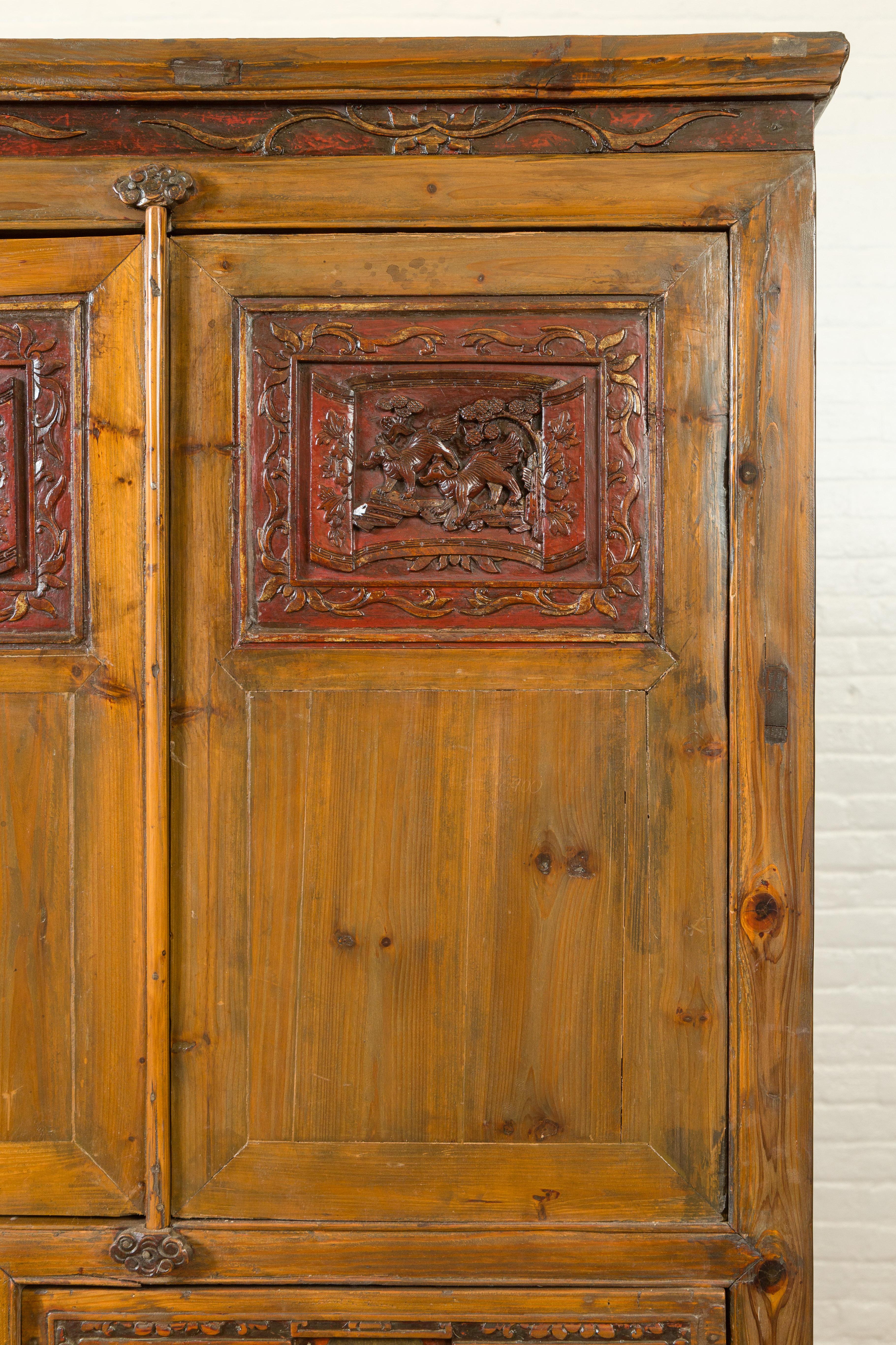 Hand-Carved Large Chinese Qing Elm Armoire with Carved Motifs and Red Lacquered Accents For Sale