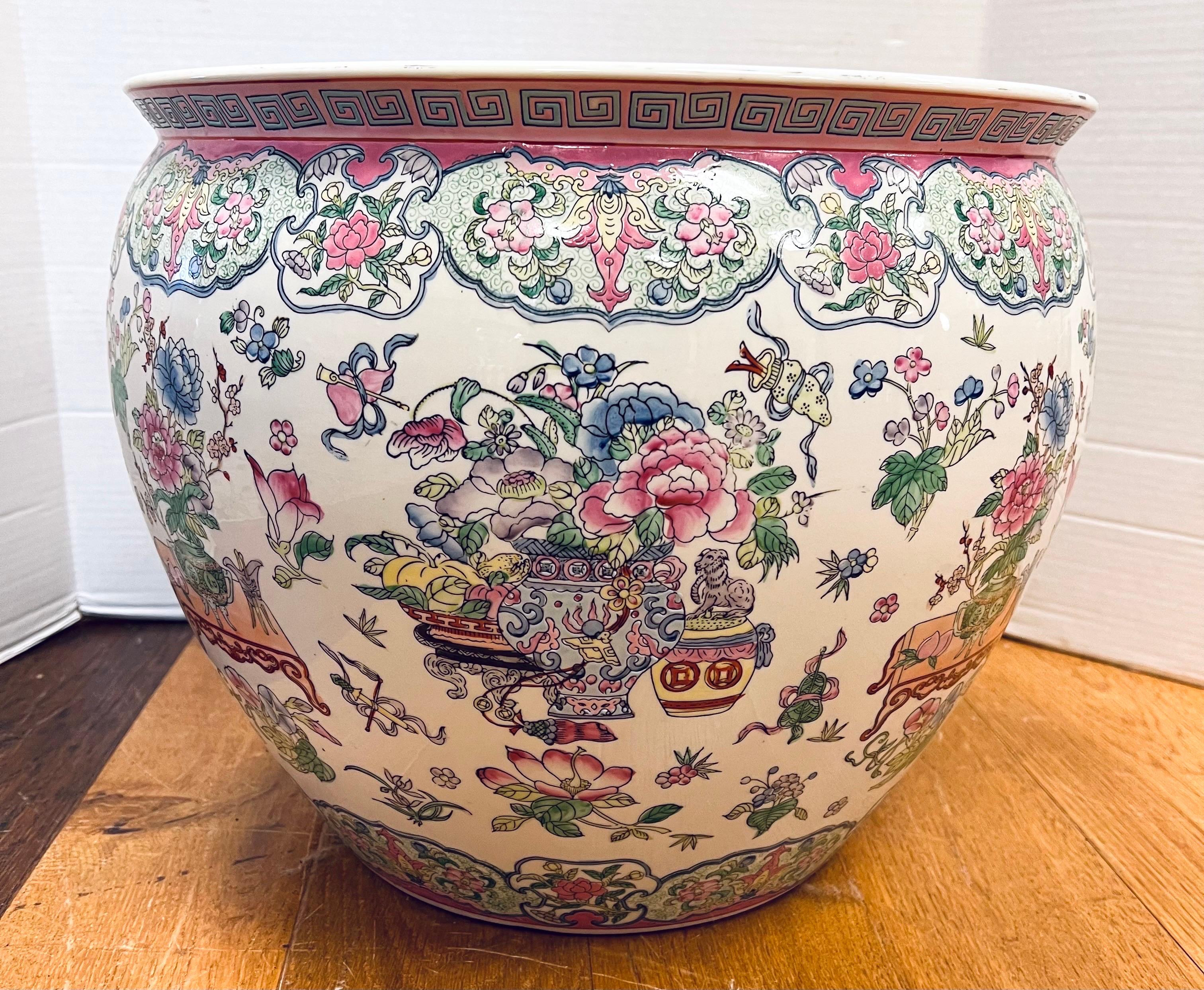 Large Chinese porcelain fish bowl features stunning hand painted floral decoration in pinks, greens, and blues making it a gorgeous decorative piece that will elevate any room. Originally used to house goldfish and koi, is fishbowl is also popularly