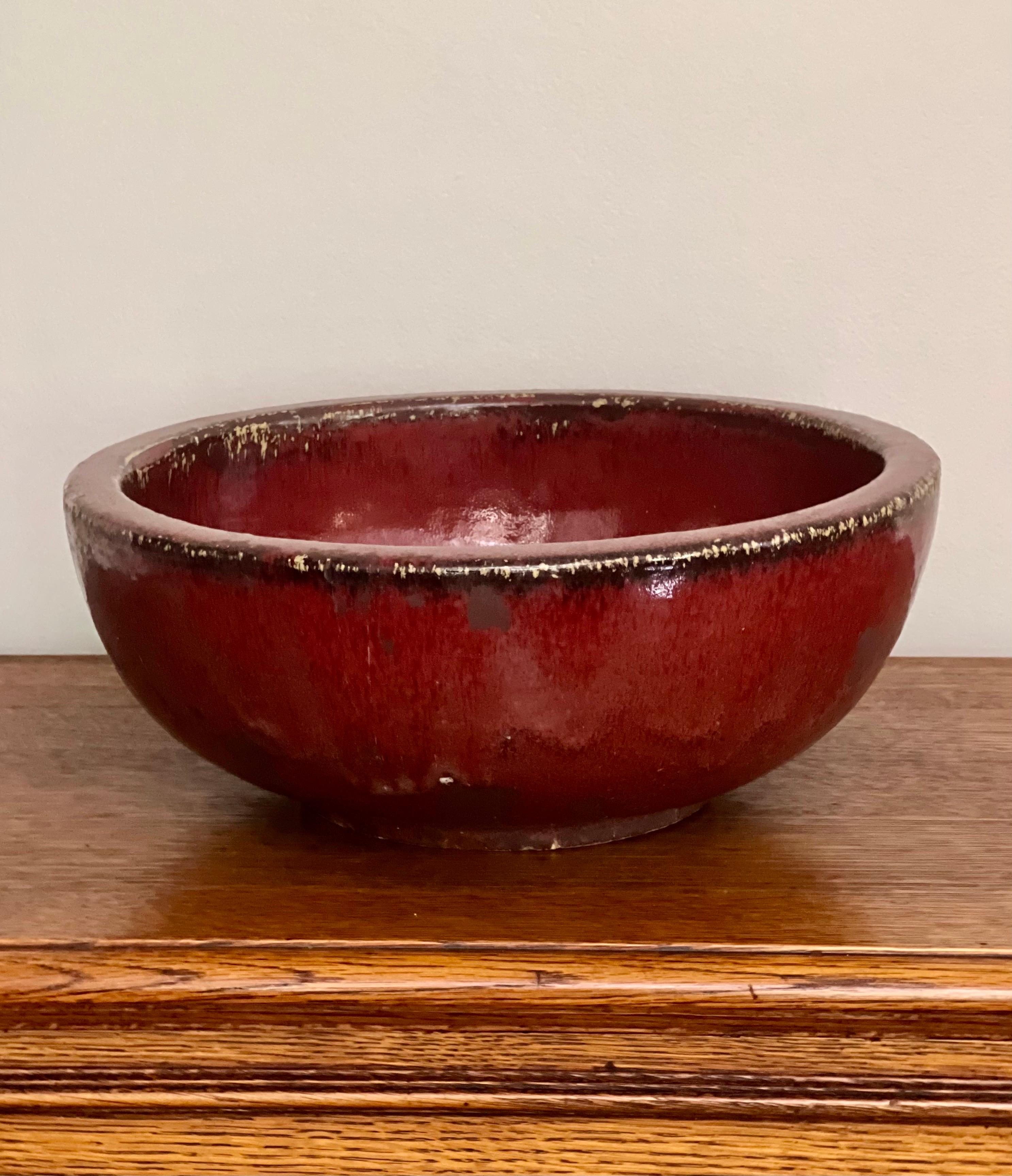 Large patinated Chinese Sang de Boeuf with Flambe glazed bowl, signed, early 20th century. A heavy, thick-bodied earthenware bowl with great color likely used for utilitarian purposes such as a brush washer or planter. A wonderful statement piece,