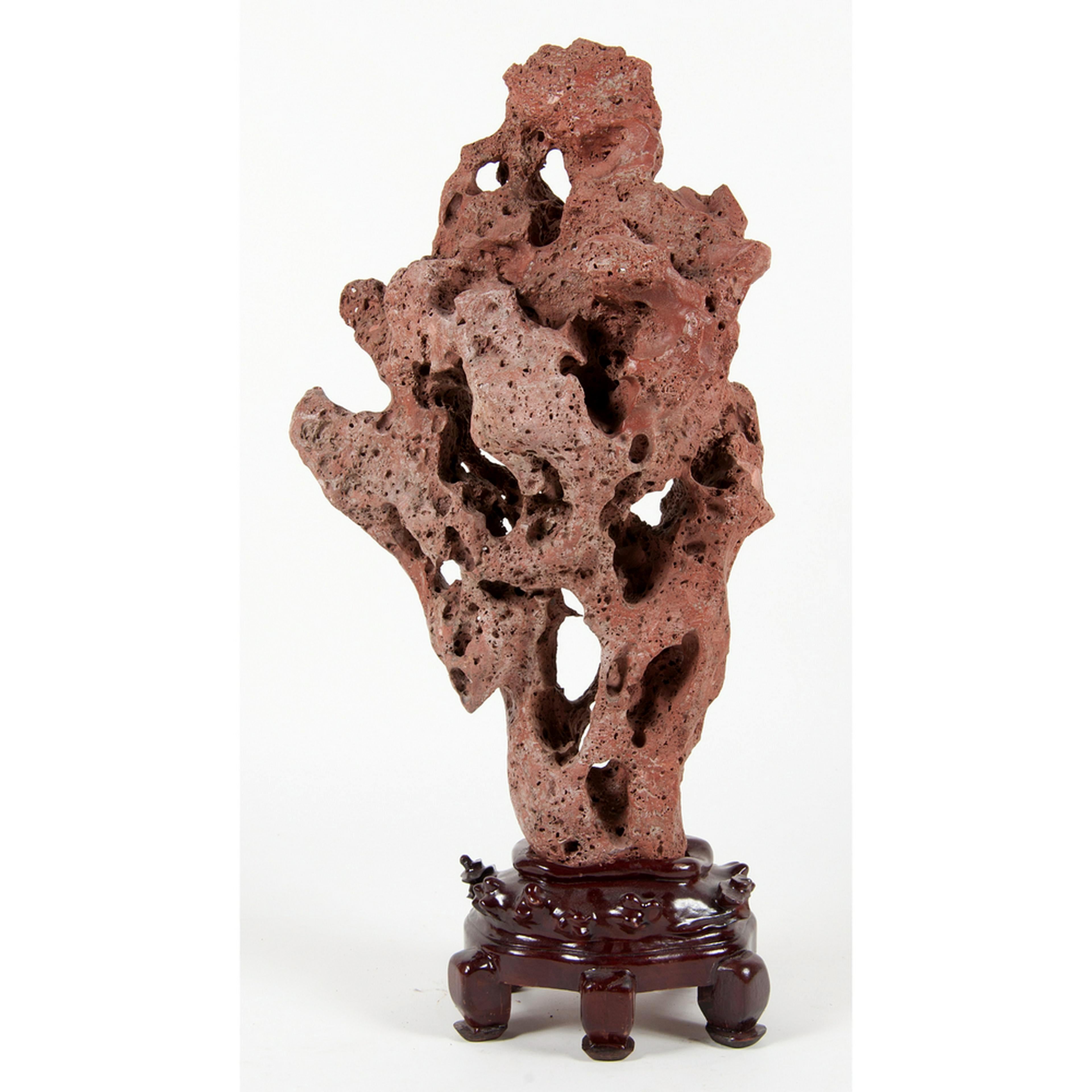 A large and dramatic Chinese Gongshi (known as meditation stone or spirit stone) from Taihu (Lake Tai) balanced on display stand. This scholar rock features a relatively red and porous surface. Its elegant mushroom cloud form resembles red coral in