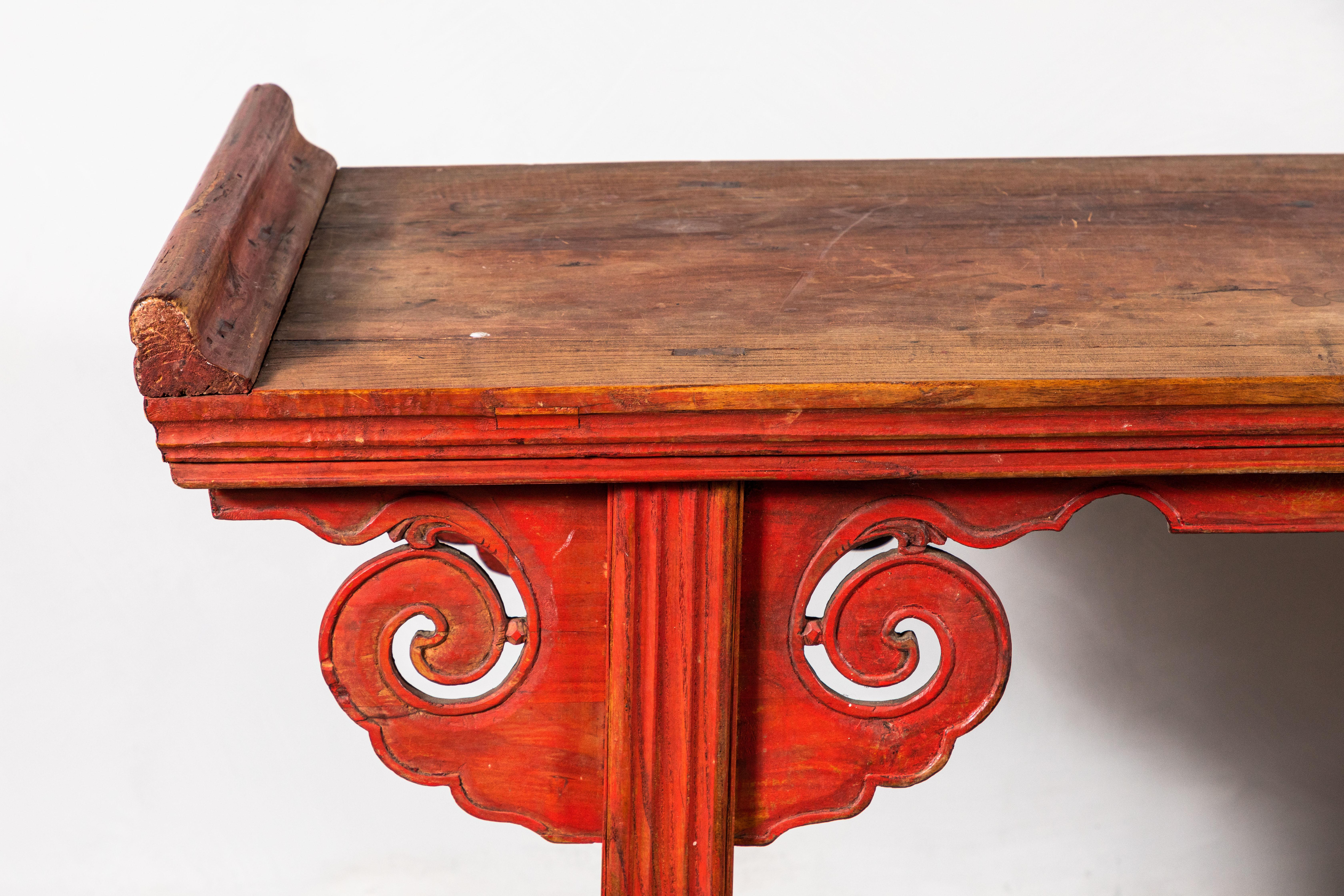 Chinese scroll console with red tones and a natural top, embellished with period details.
