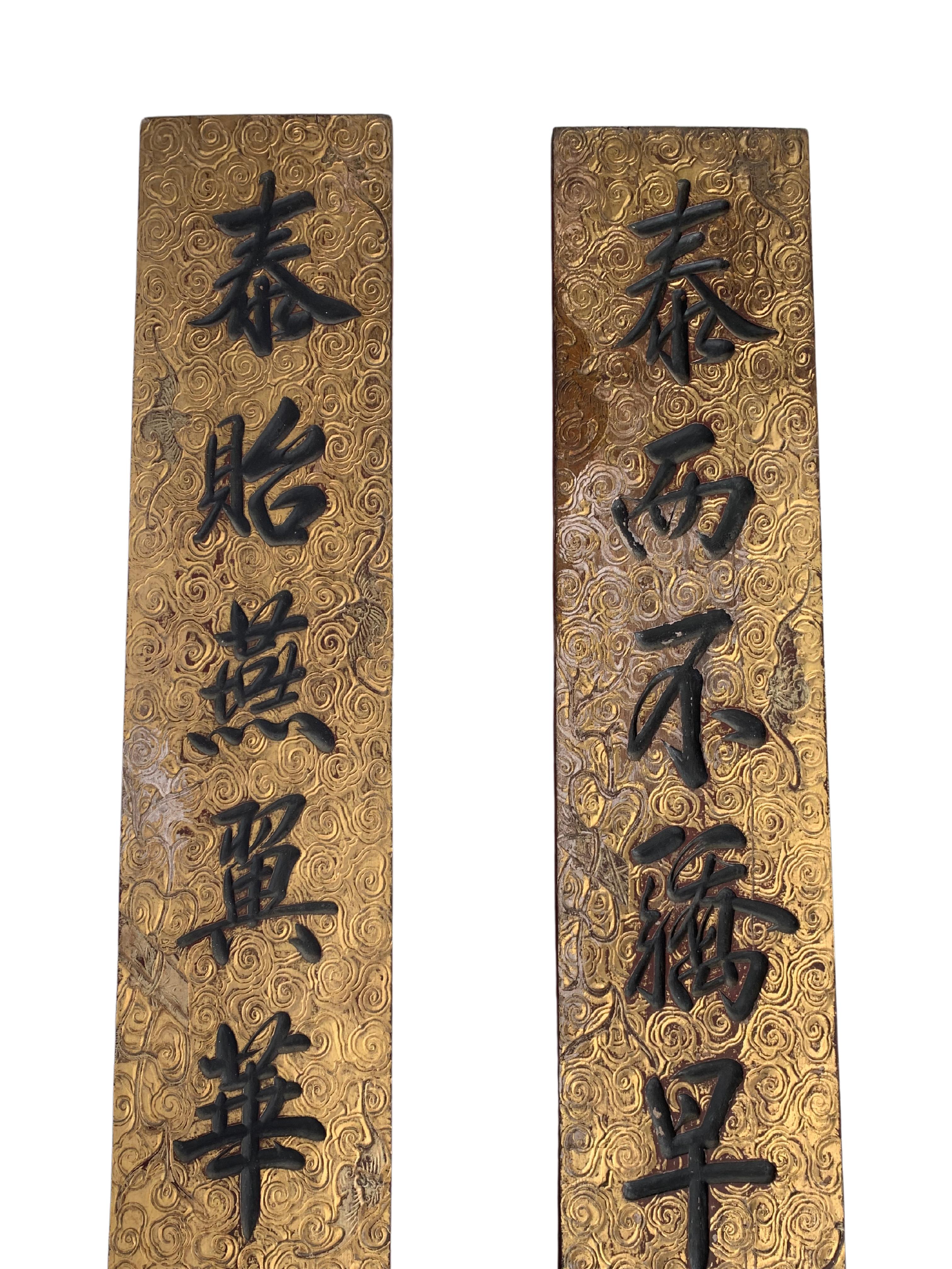 An exquisite set of Gilded Qing Dynasty Vertical Signboards from the early 20th Century. The signboards feature a stunning cloud patterning throughout and large black painted Chinese characters. Their edges feature a wonderful red paint finish. The