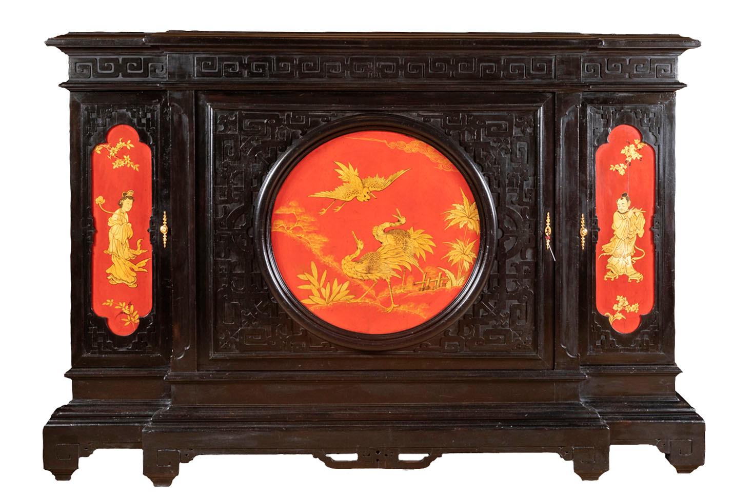 Large cabinet opening by three door leaves in black lacquered wood with a red lacquered decor and gilt highlights. Rectangular body in carved and black lacquered wood with a decor of Greek meanders frieze on the entablature and geometrical motifs on