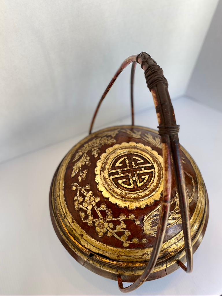 Large Chinese wooden basket.
High handle with red lacquer and gold leaf design. Having a family crest to the top.