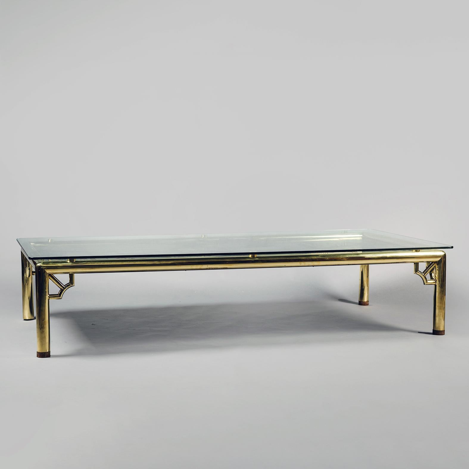 A Very Large Chinoiserie Lacquer, Polished Brass and Glass Coffee Table. In the manner of Maison Jansen. 

The glass top above a Chinese-style 'Coromandel lacquer' panel. The tubular brass frame and legs joined by pagoda-like angle brackets.

Most
