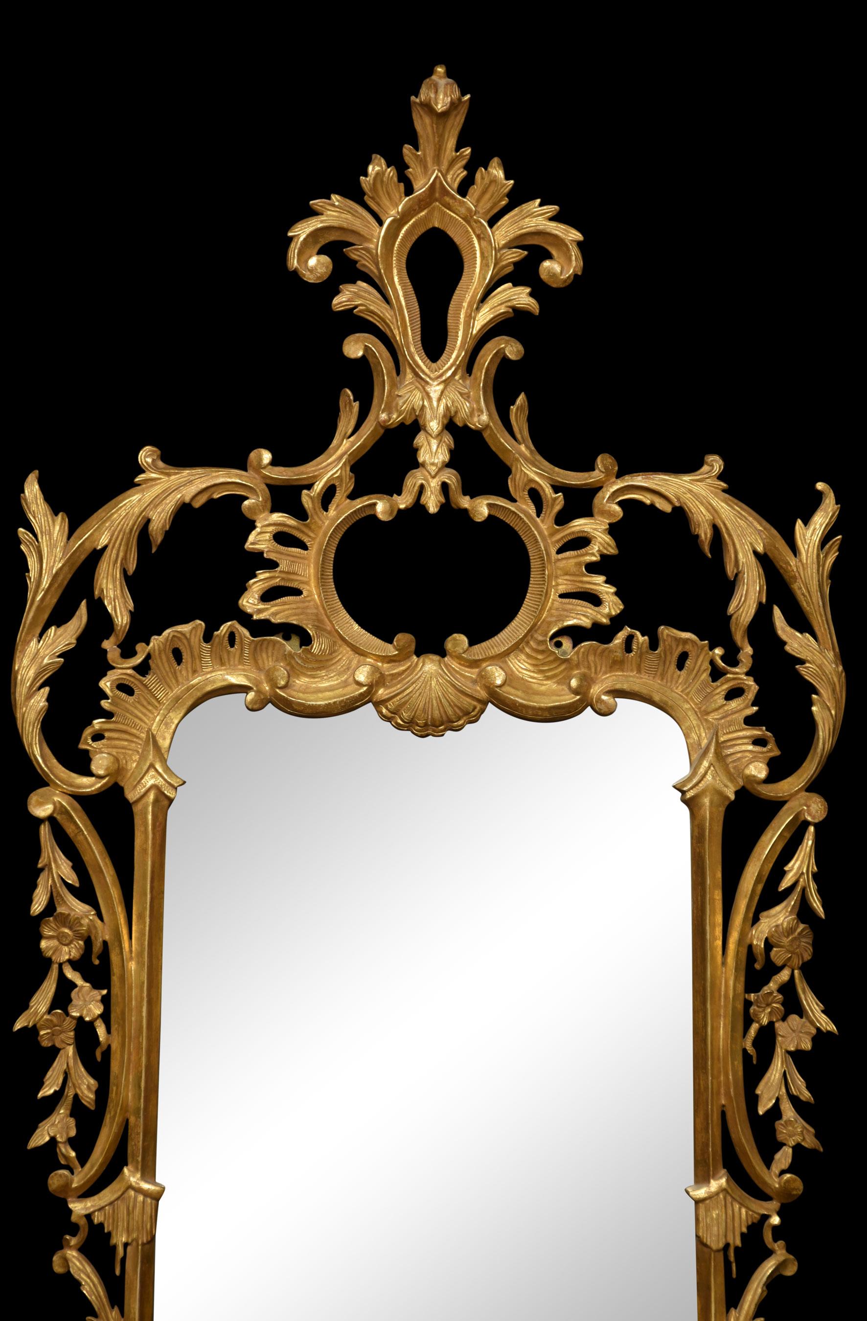 Georgian style giltwood mirror. The original cartouche-shaped bevelled plate mirror within a conforming frame elaborately carved with rocaille and c-scrolls.
Dimensions
Height 58.5 Inches
Width 26 Inches
Depth 3.5 Inches.
 
