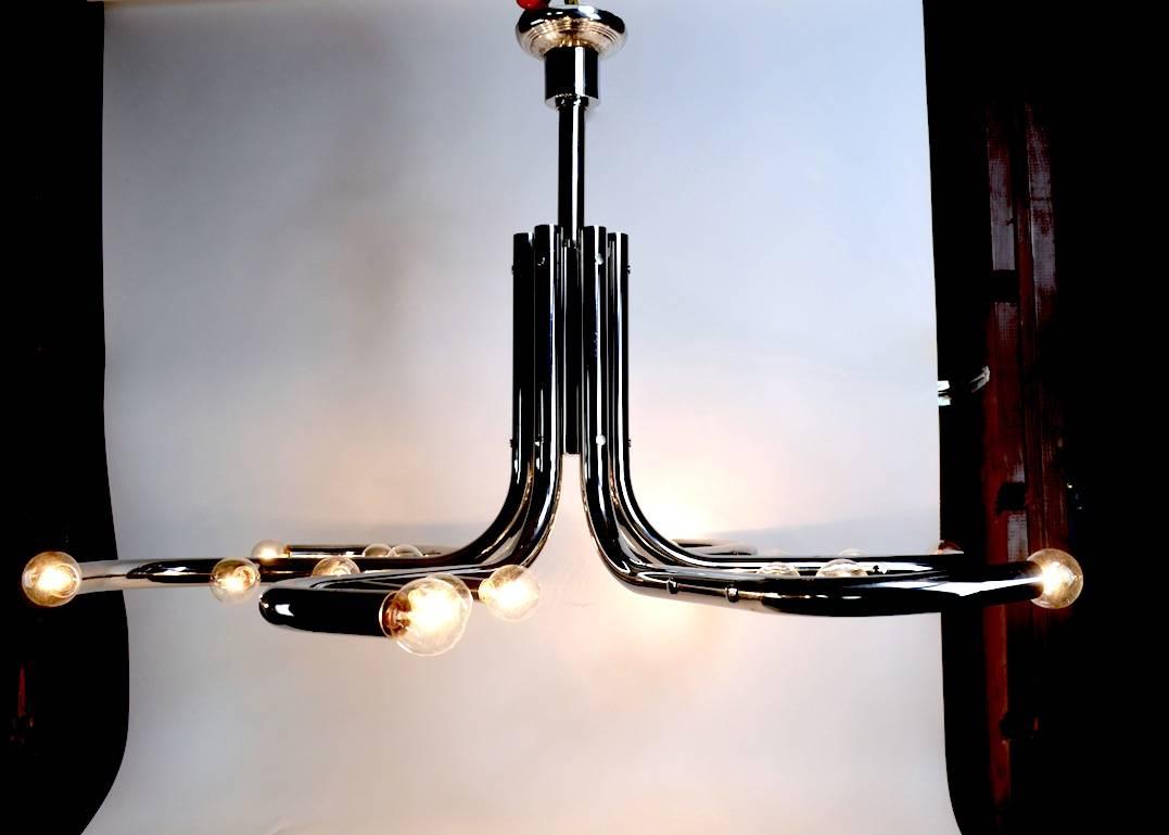 Impressive tubular chrome chandelier, with six curved arms each having three bulbs, circa 1970s, original, clean, and working condition, probably American in the Italian style. Hard to find chandeliers of this scale, currently has 26 inch drop,